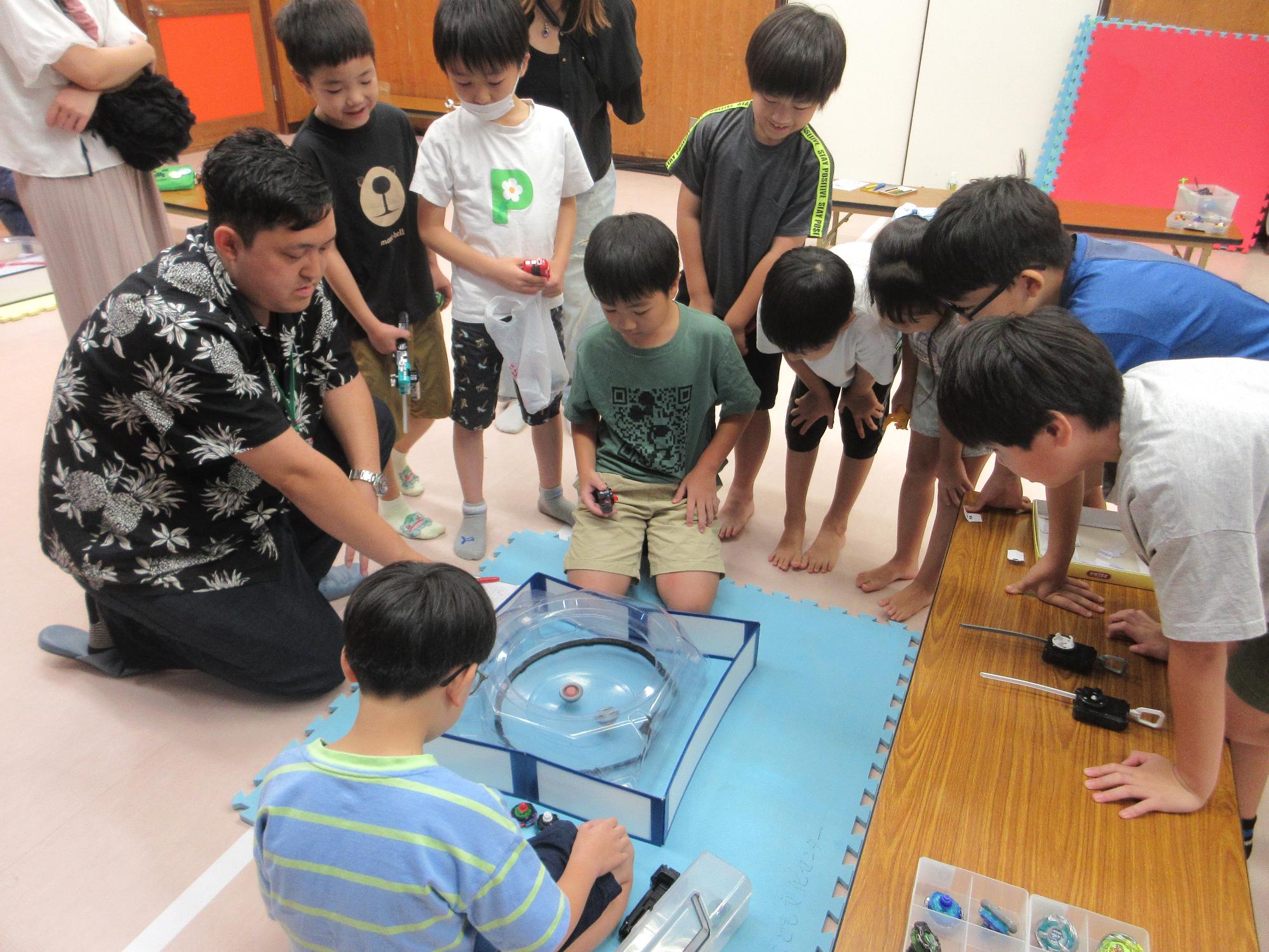 ベイブレードをする子どもたちの写真