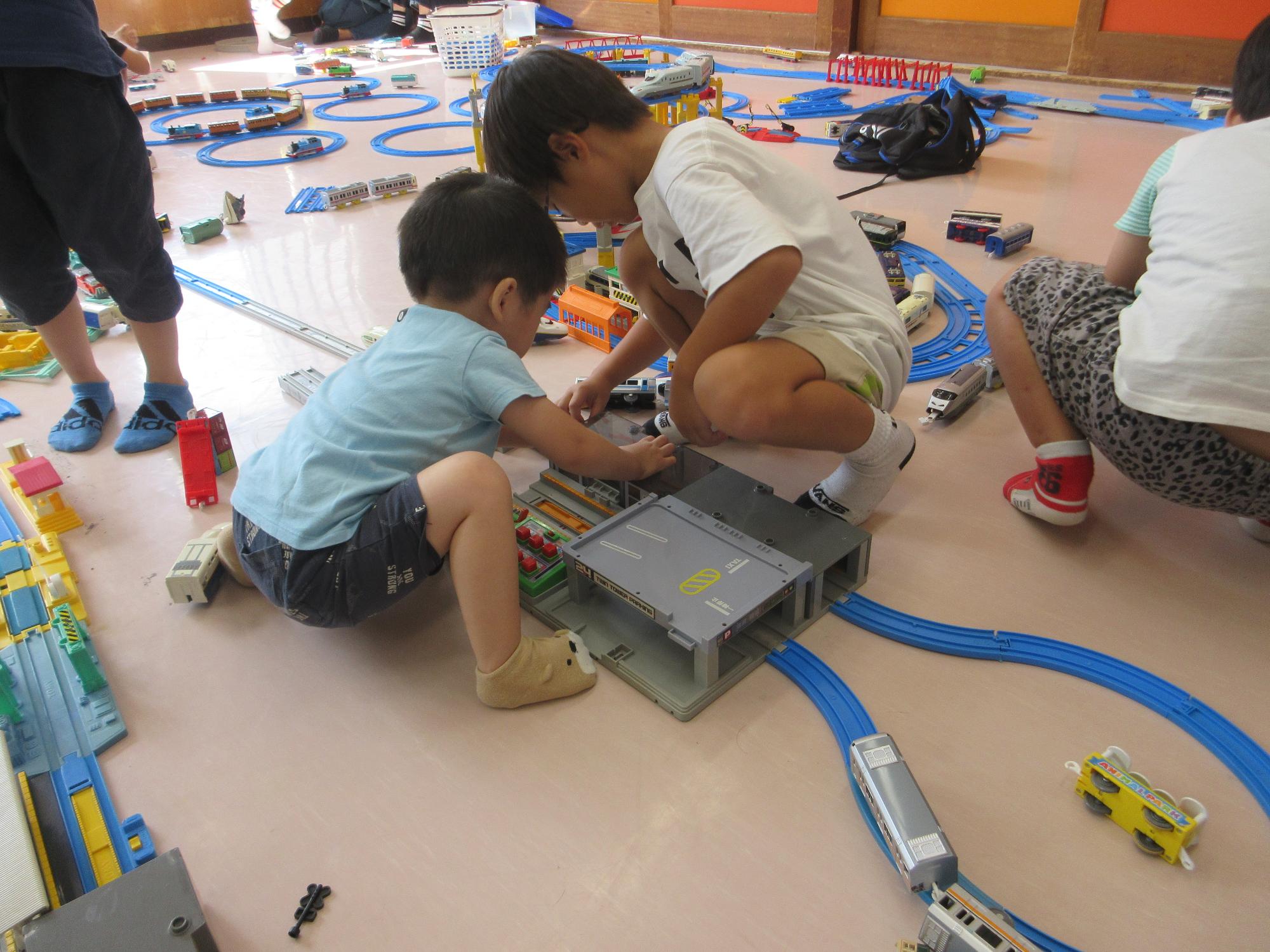 プラレールで遊ぶこどもたちの写真