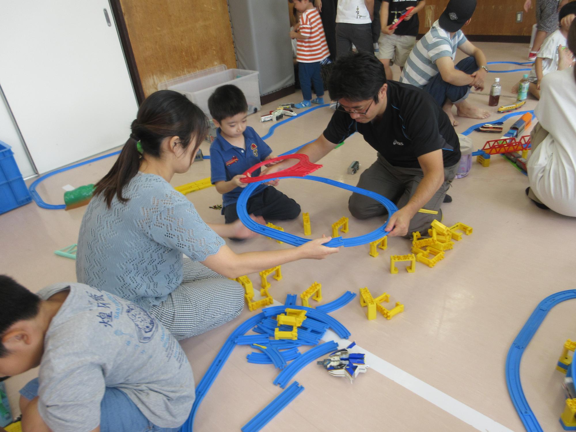 プラレールで遊ぶこどもたちの写真