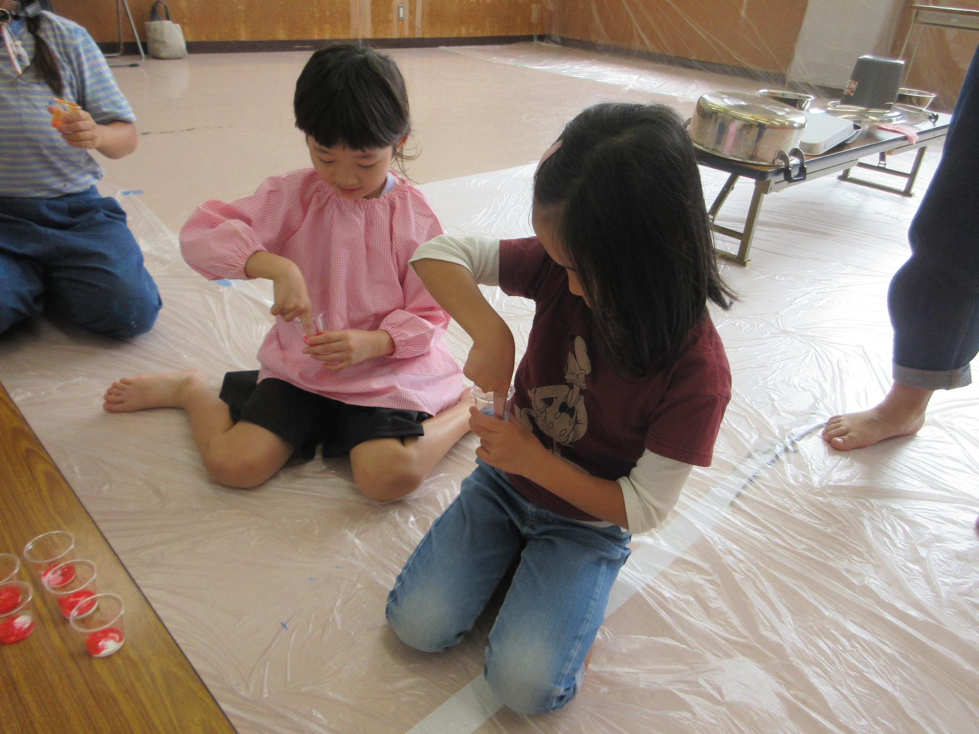 指を使って絵具を混ぜる様子