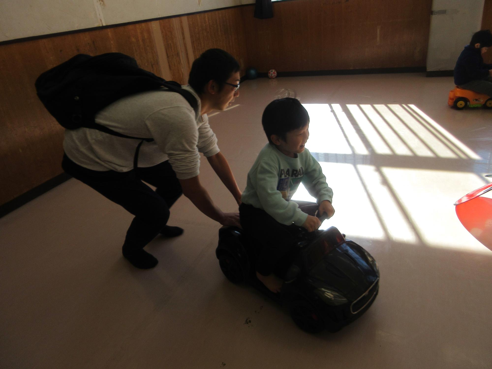 車で遊ぶこどもたちの写真