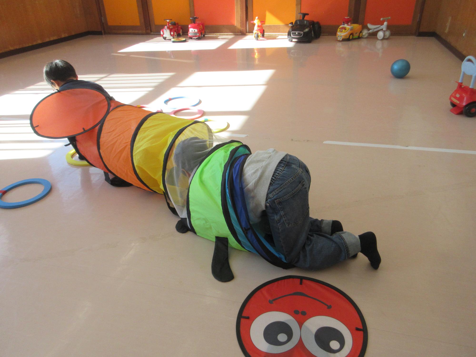 トンネルで遊ぶこどもたちの写真