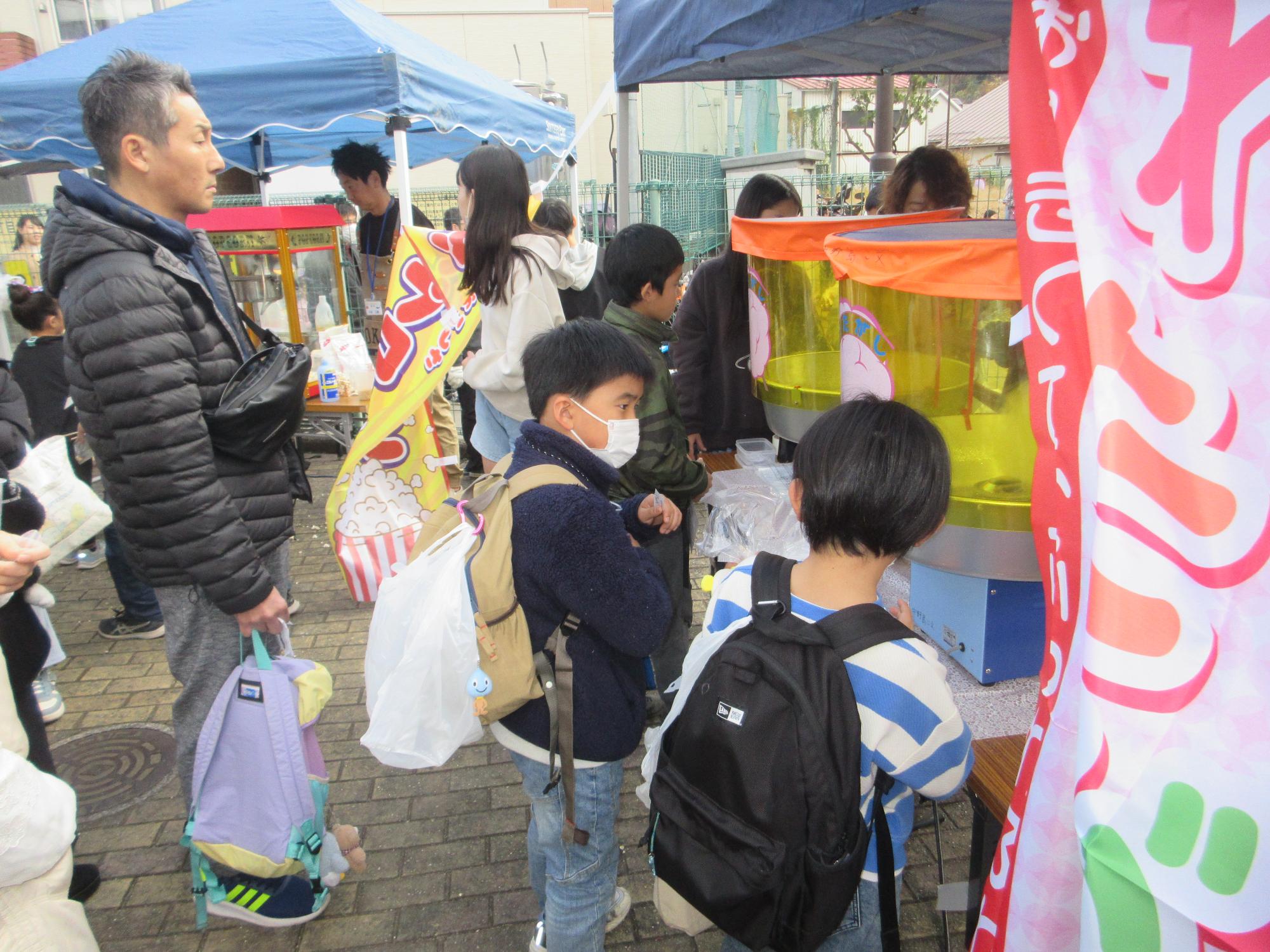 わたあめを買うこどもたちの写真