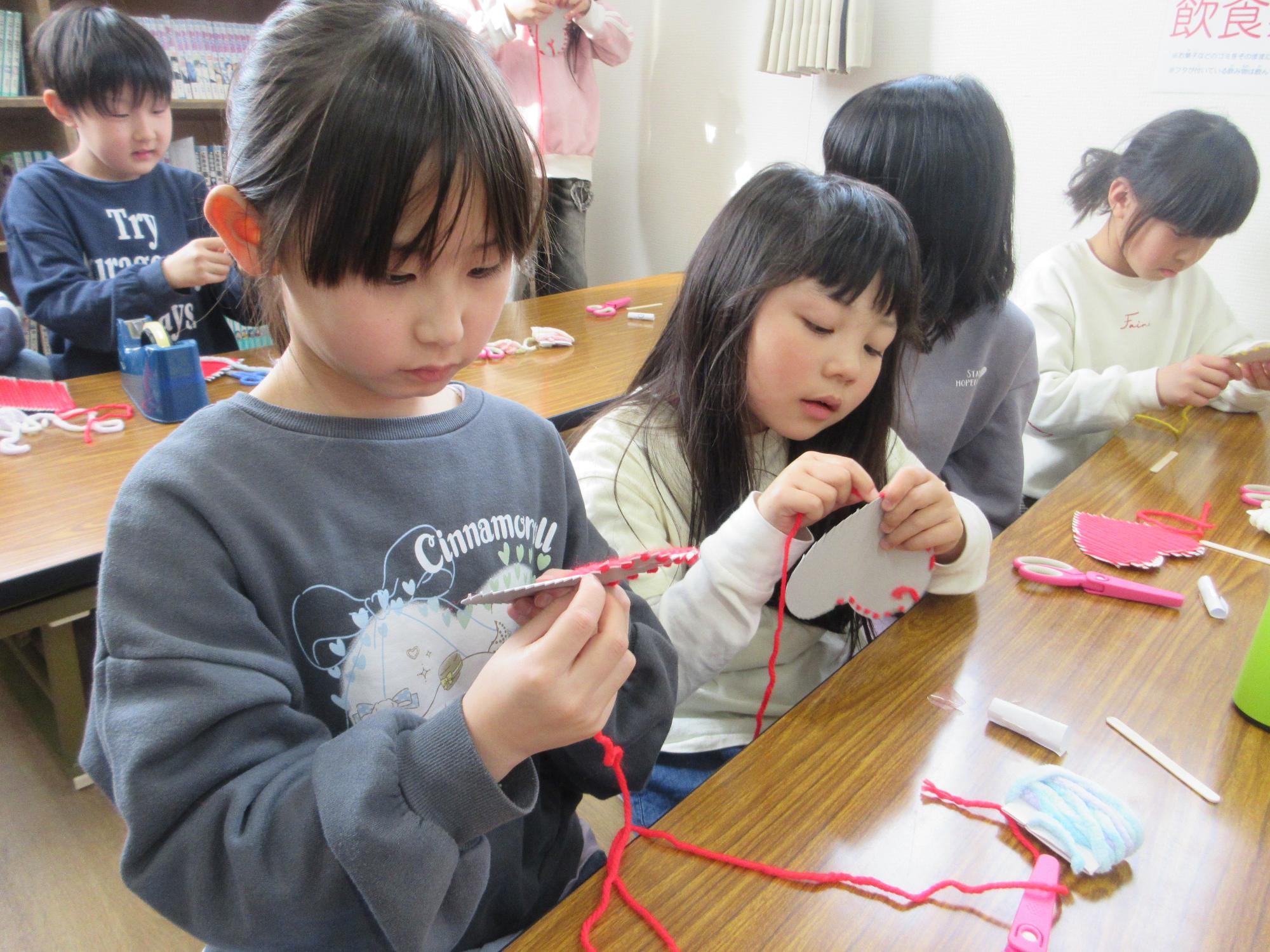 ハートのコースターを作る子どもたち