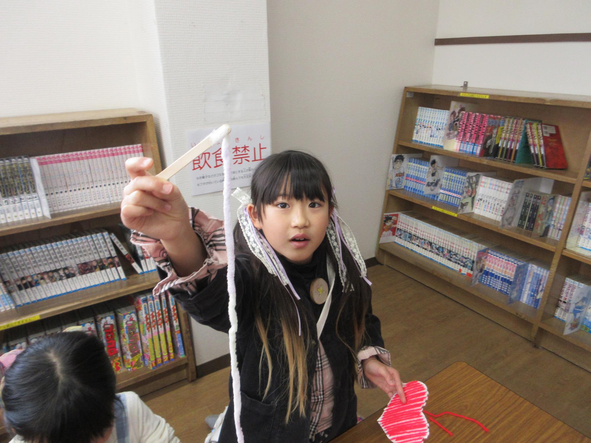 毛糸を見せているこども