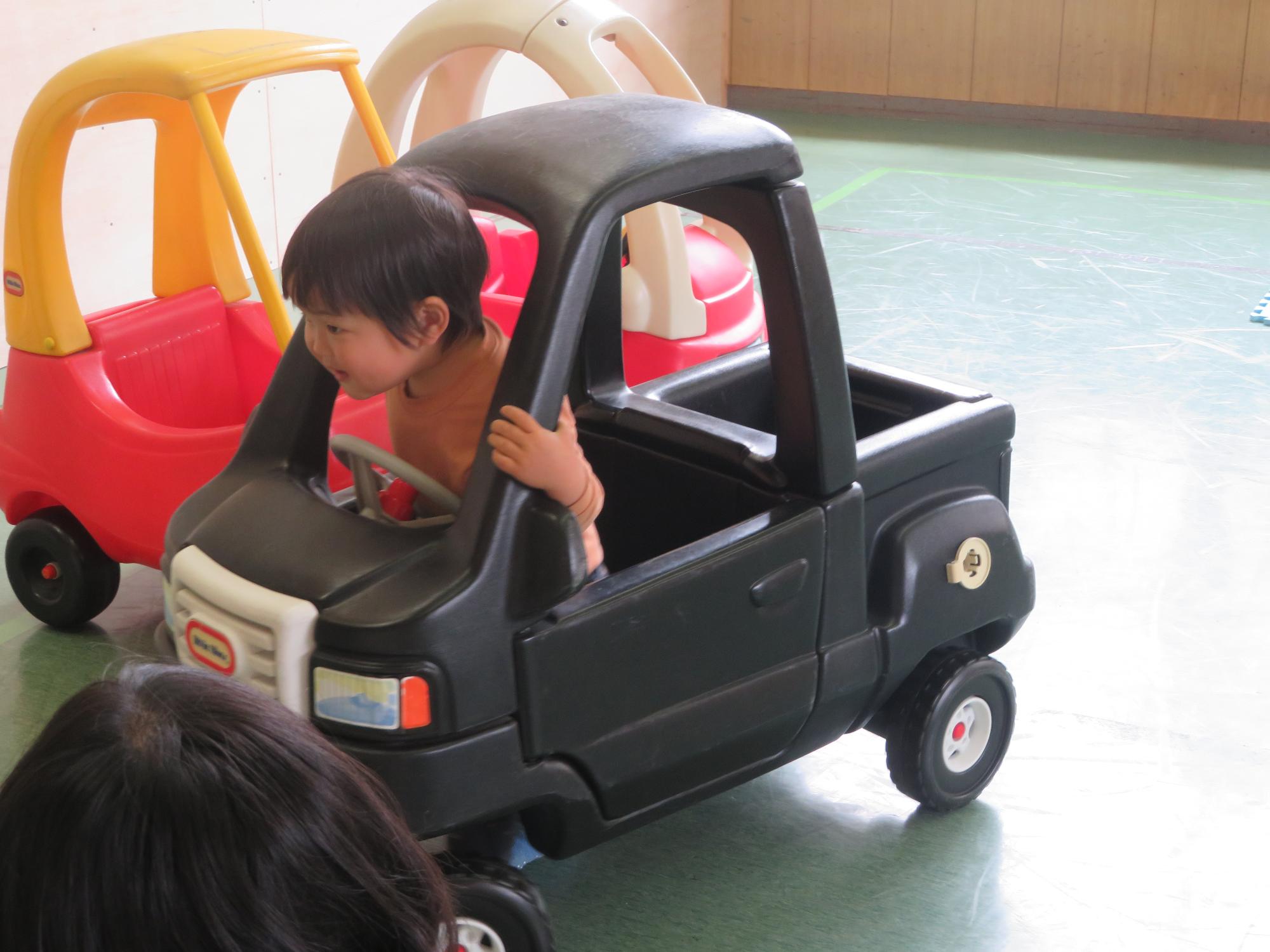 車のおもちゃに乗る幼児の写真