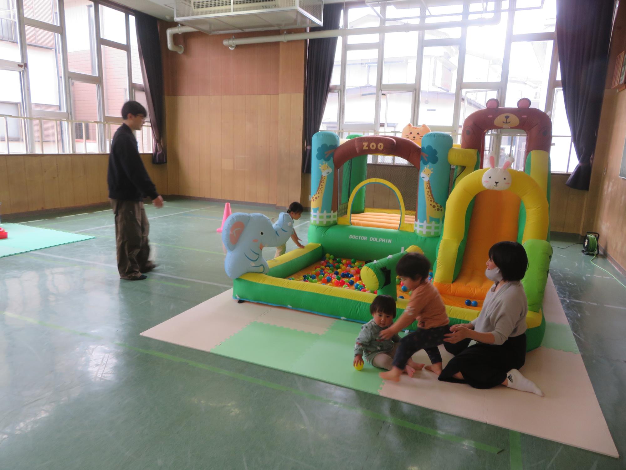 大型エア遊具と幼児親子の写真