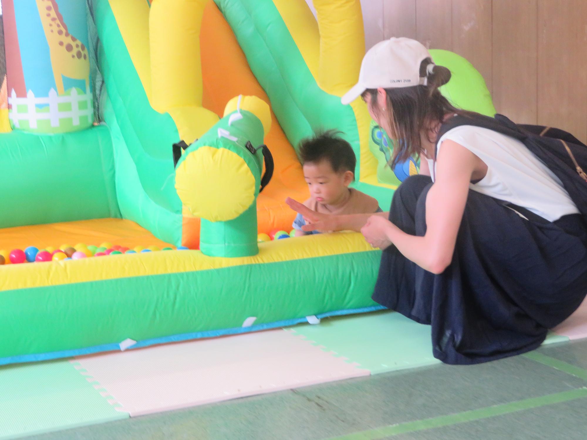 大型エア遊具で遊ぶ幼児親子の写真