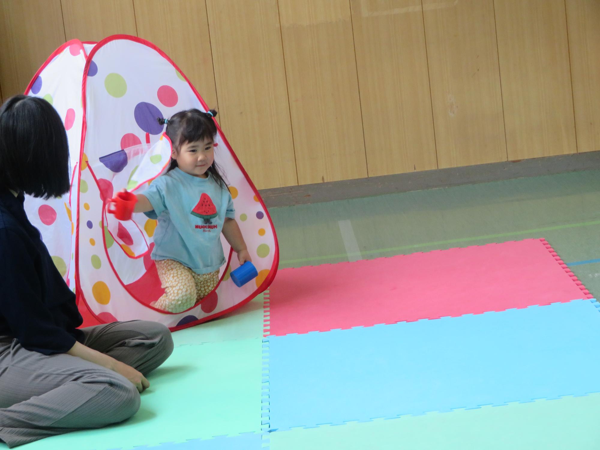 テントであそぶ幼児親子の写真