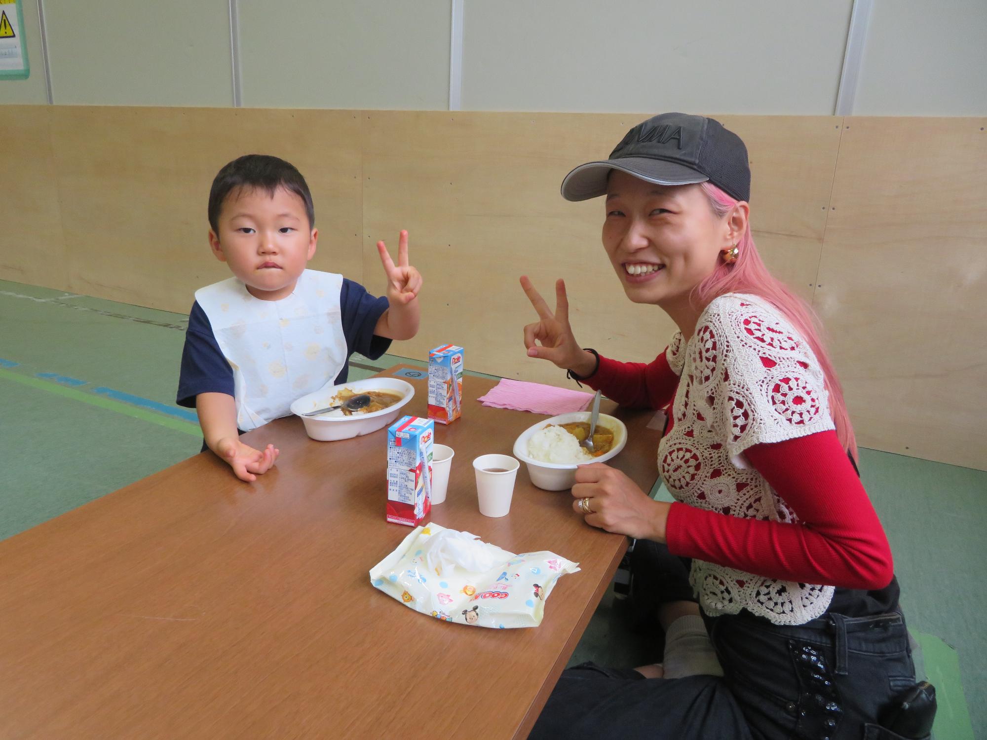 ピースサインする親子の写真