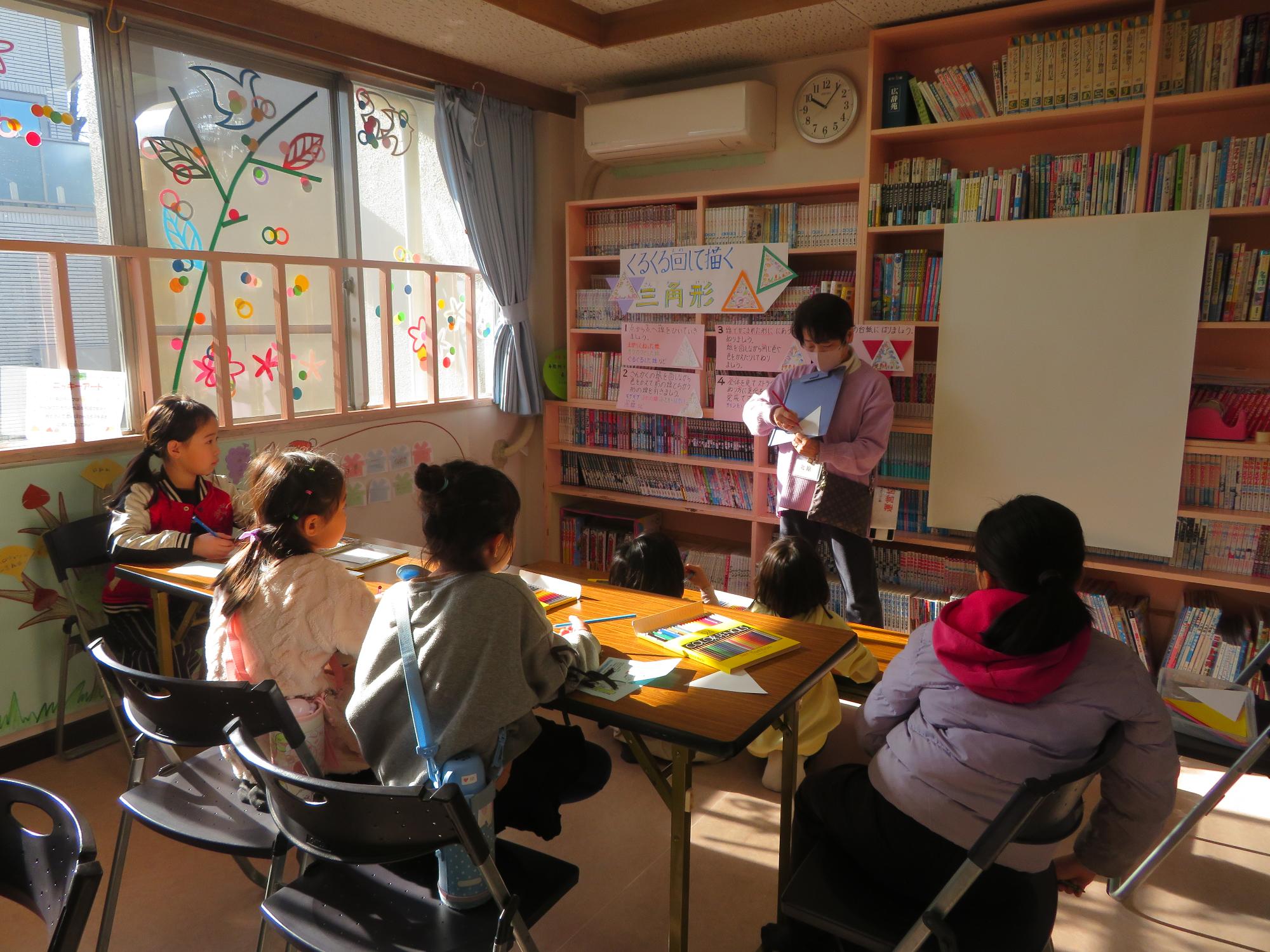 三角アートの説明を聞いている写真