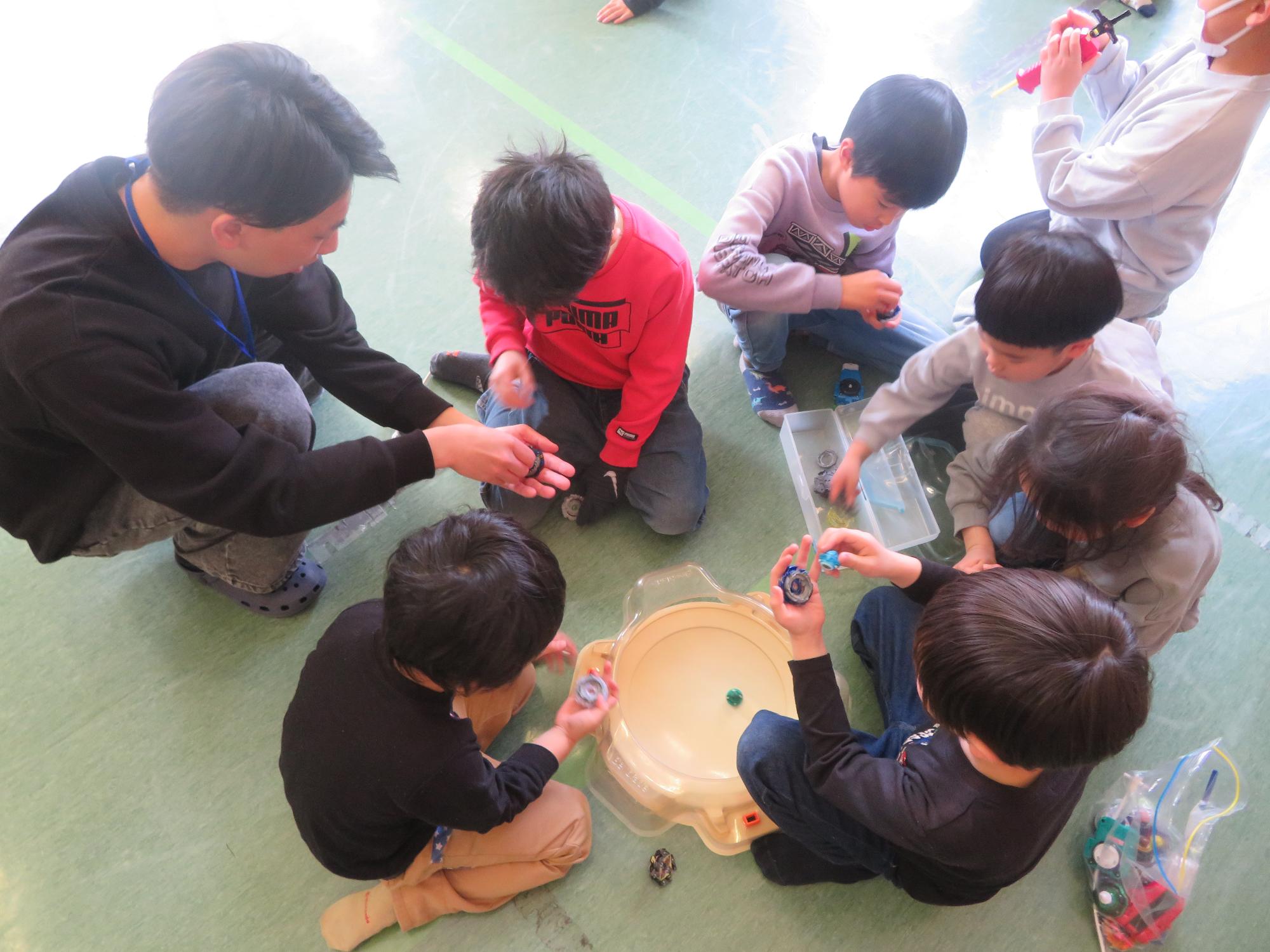 遊び方を教わる子どもたちの様子の写真