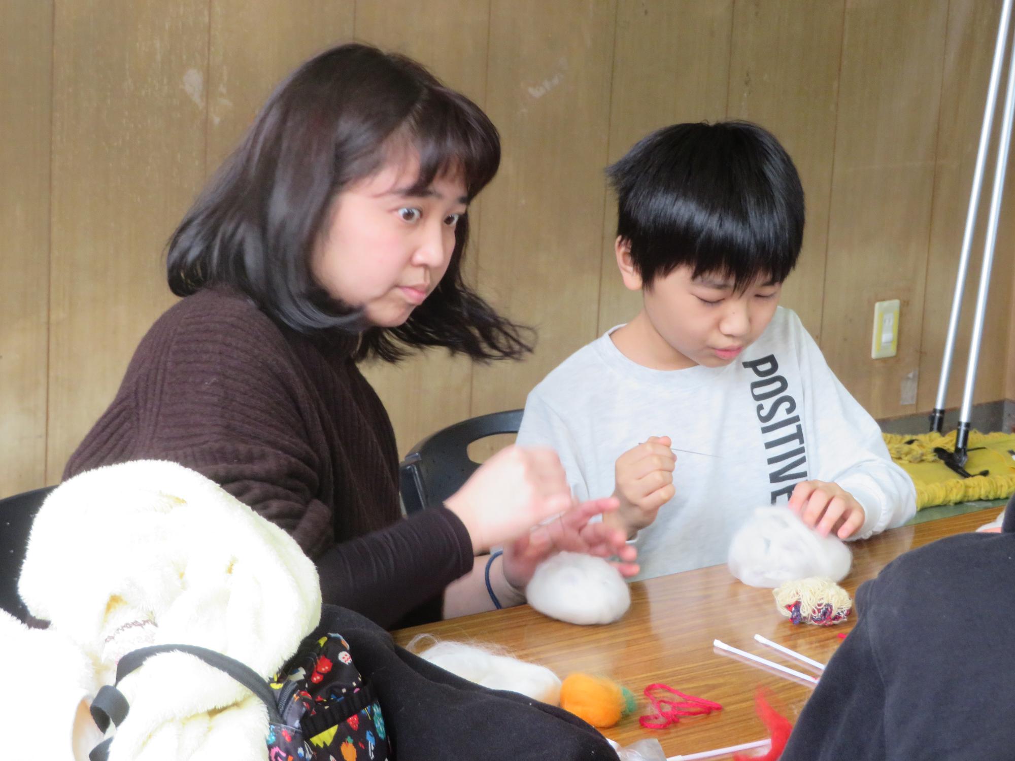 保護者と一緒に鏡餅を作る参加者の写真