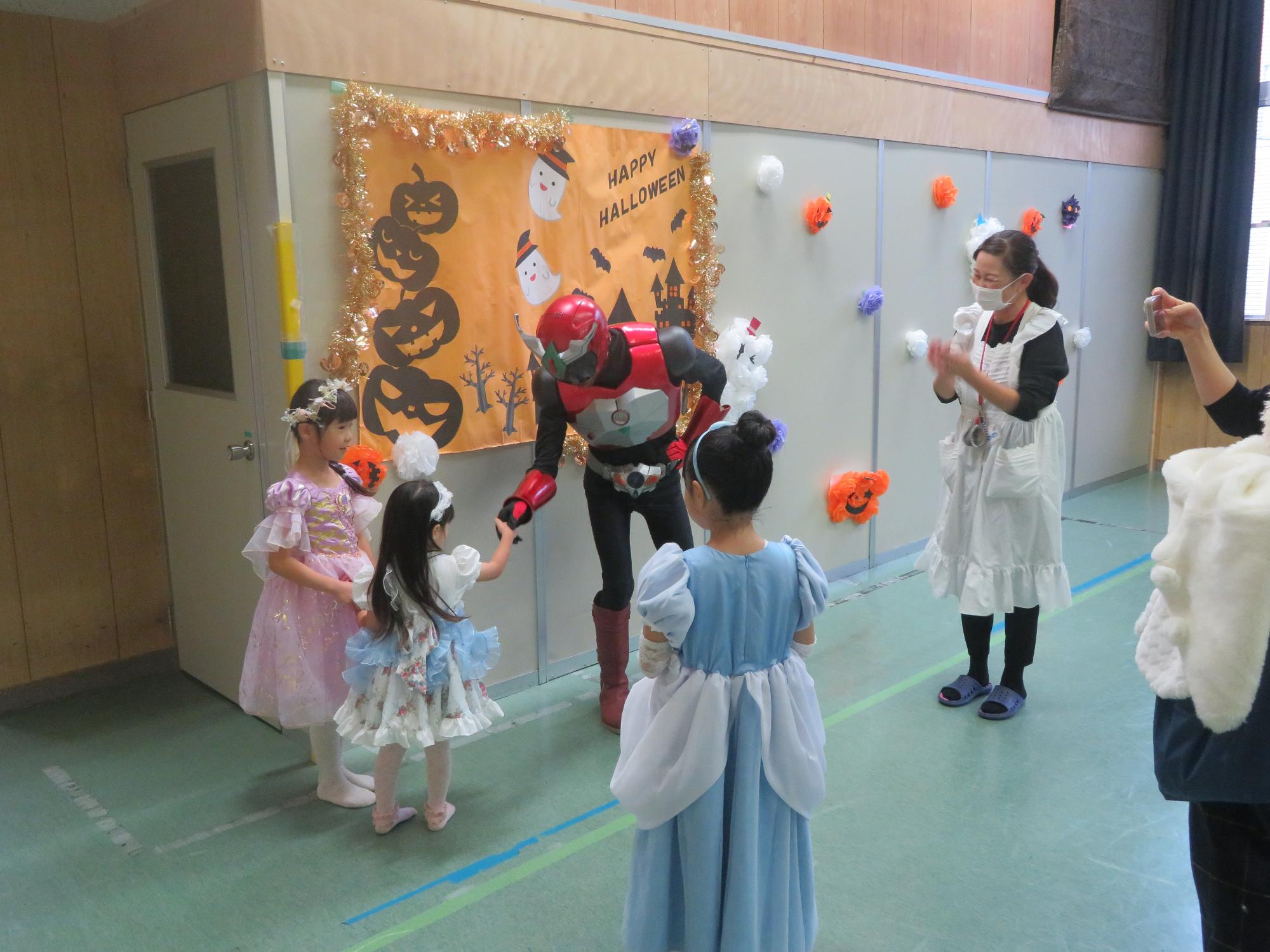 プリンセスの仮装をしたこどもがイクターと握手をしている写真