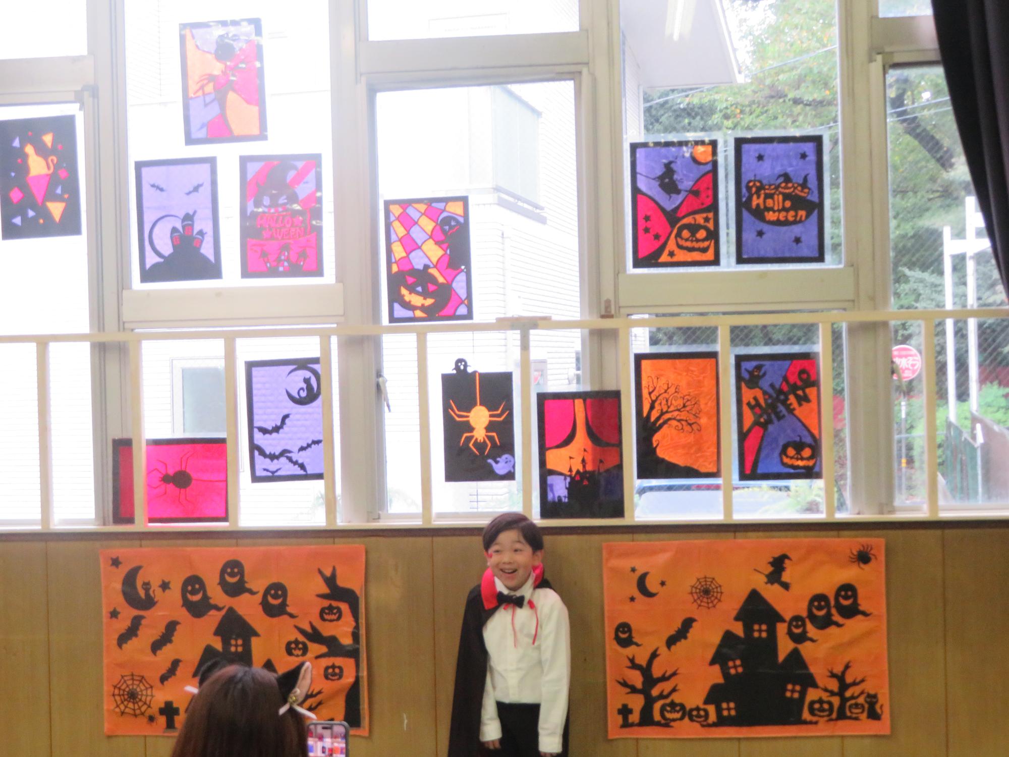 ステンドグラス風コーナーでドラキュラの仮装をしたこどもが写真を撮っている写真