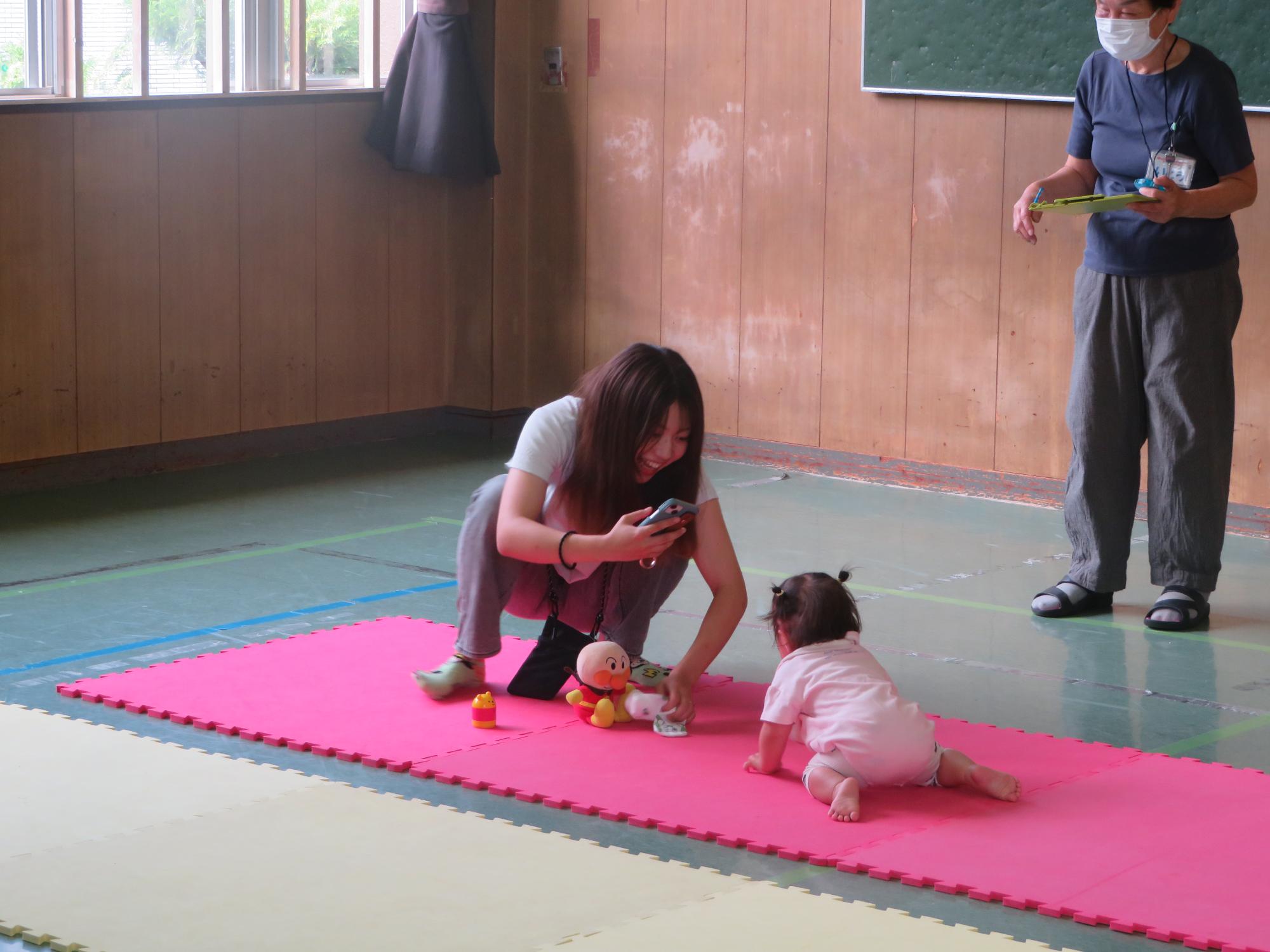 お気に入りの玩具で気をひいてゴールを目指す選手と保護者の様子の写真