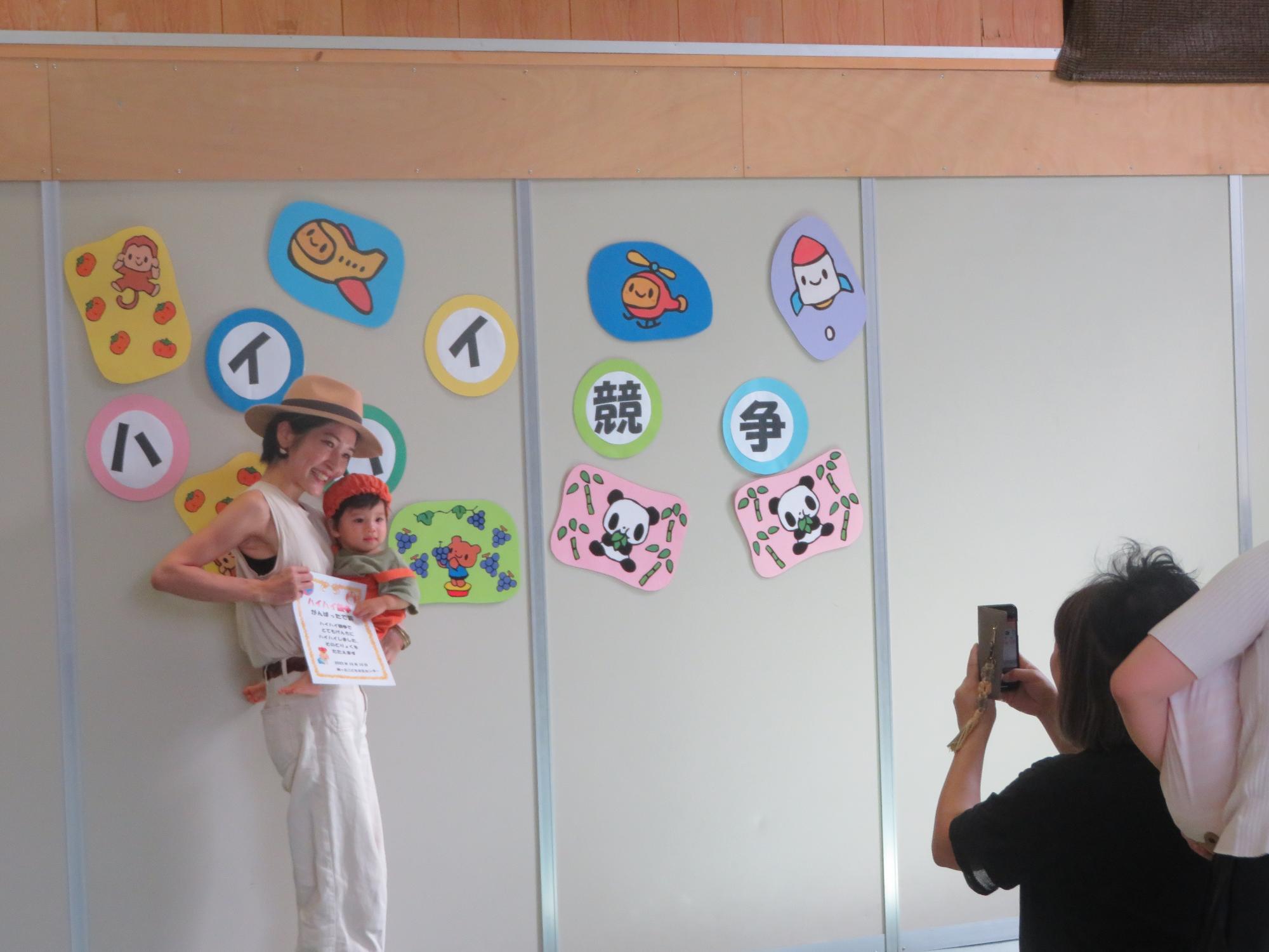 記念撮影をする幼児親子の写真