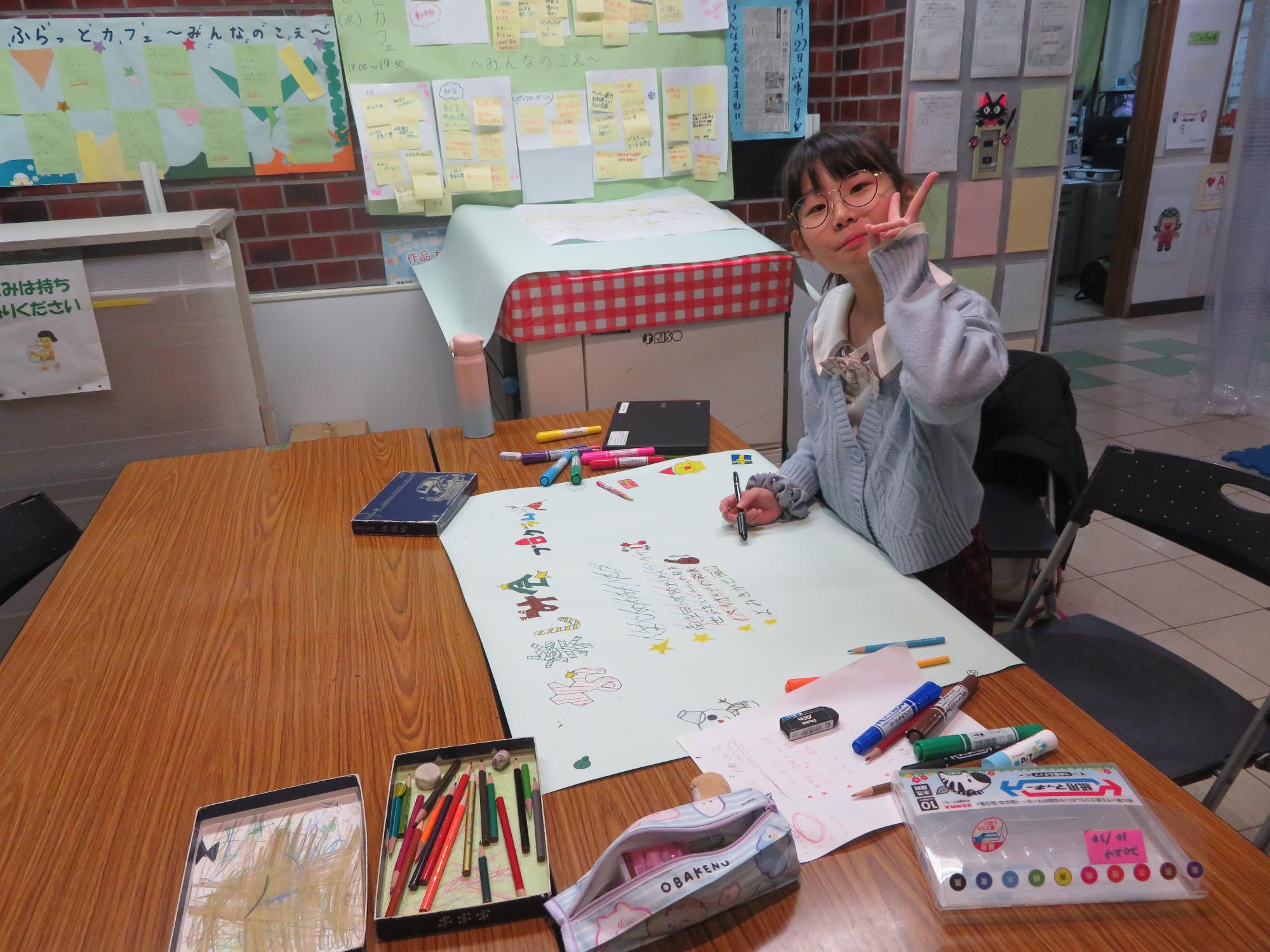 ピースサインをする小学生の写真