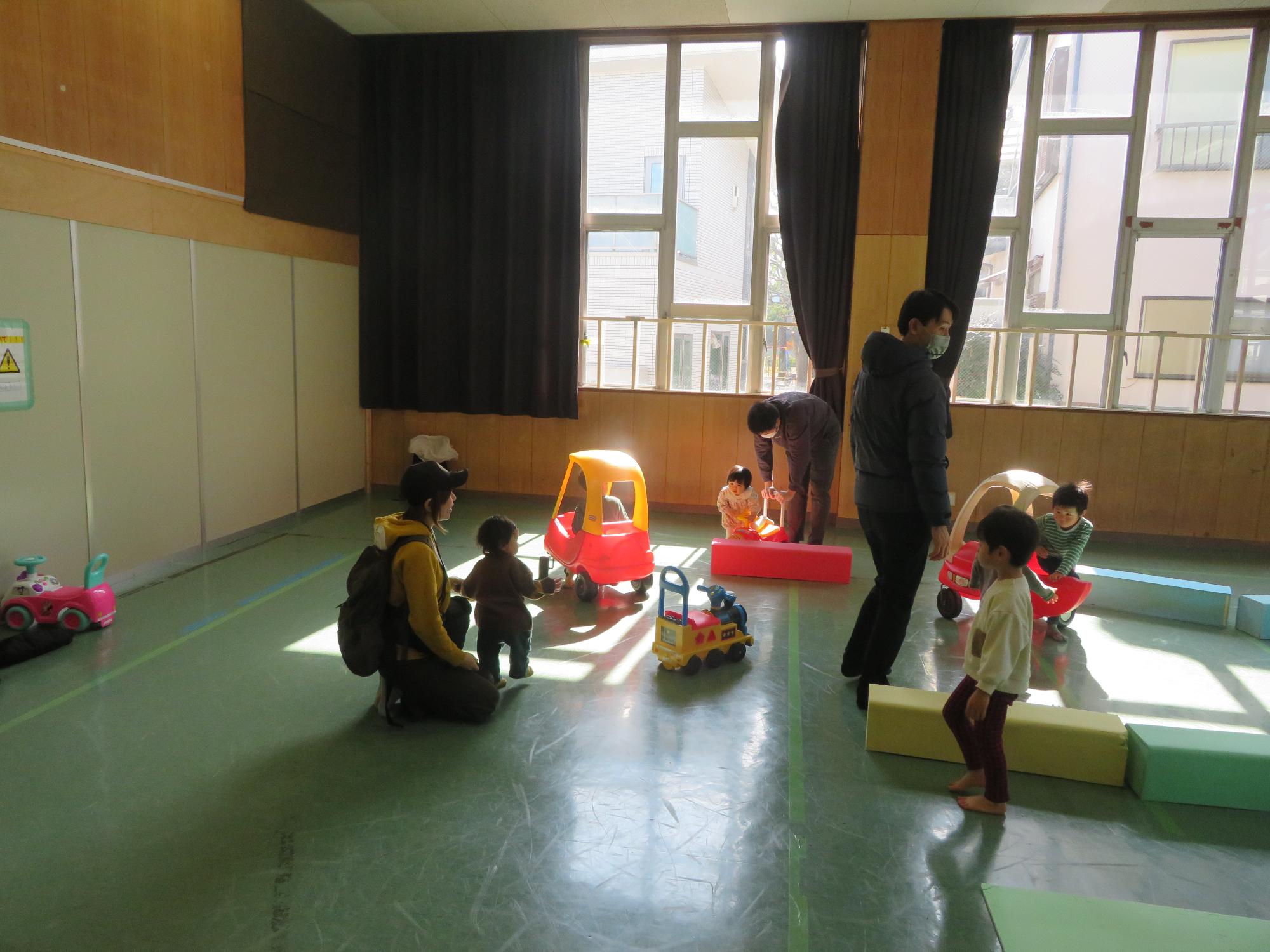乗り物遊具やブロックで遊ぶ幼児たちの写真