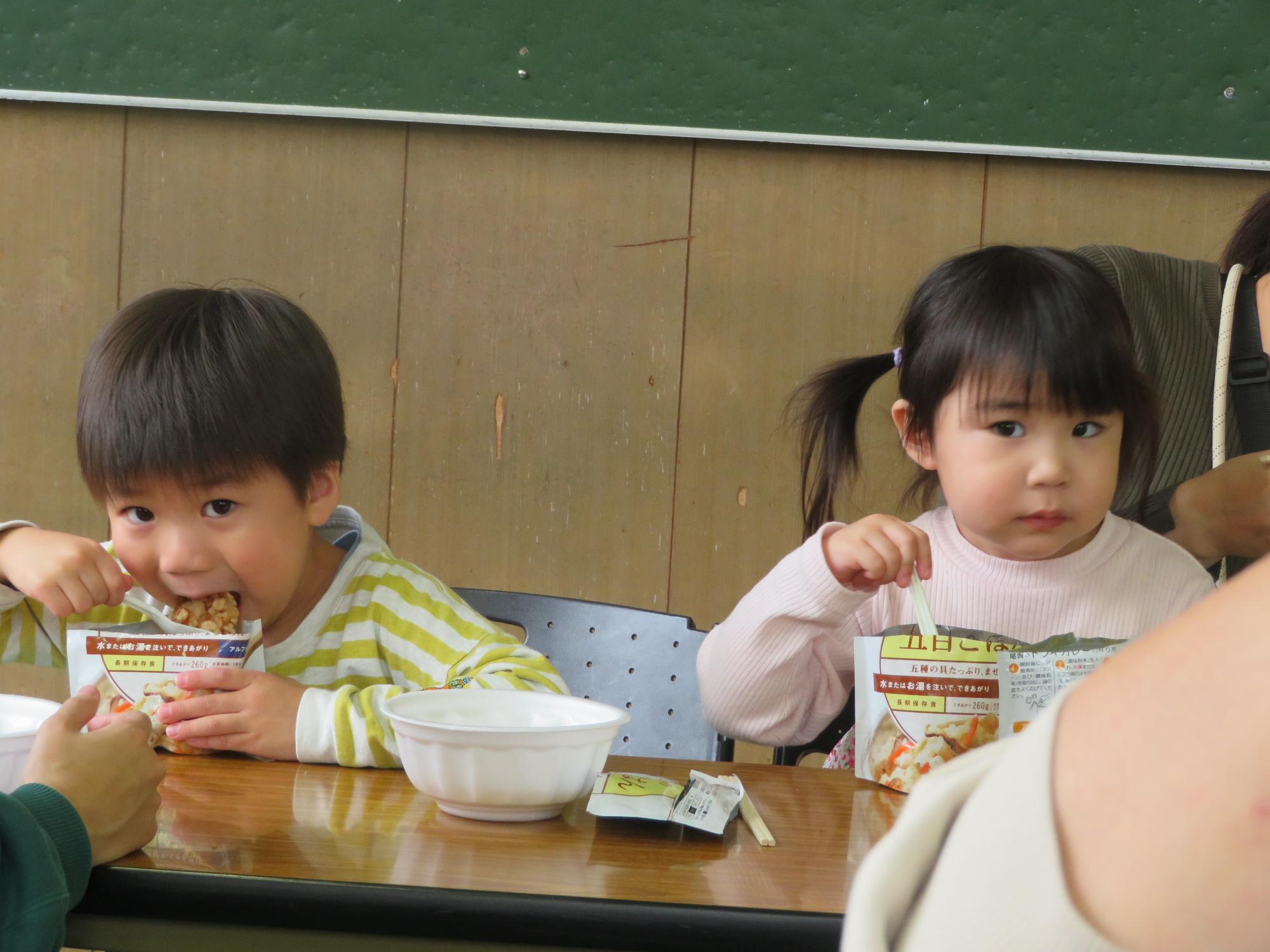 豚汁とアルファ米を食べる乳幼児の写真