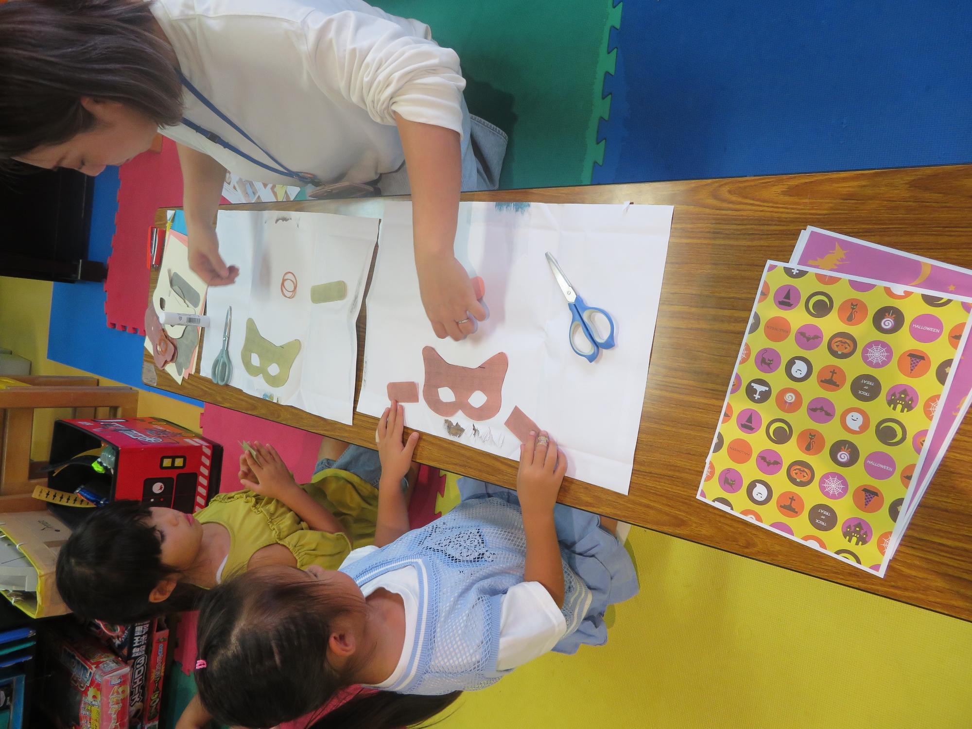 作業の説明を聞いているこどもたちと職員の写真