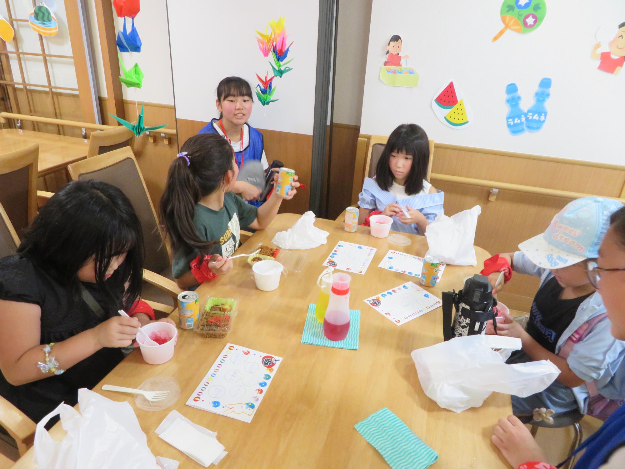 夏祭りでみんなで食事をしている写真