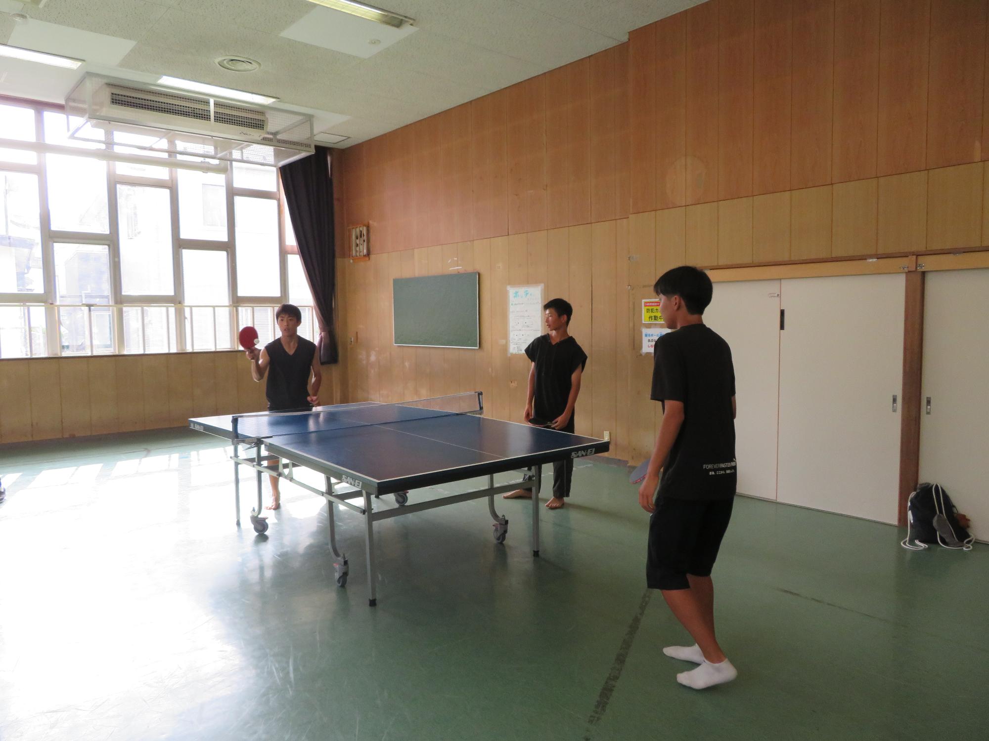 卓球をする中学生3人の写真