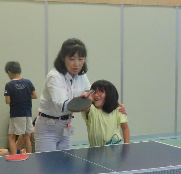 館長が児童に打ち方を教えている様子の写真