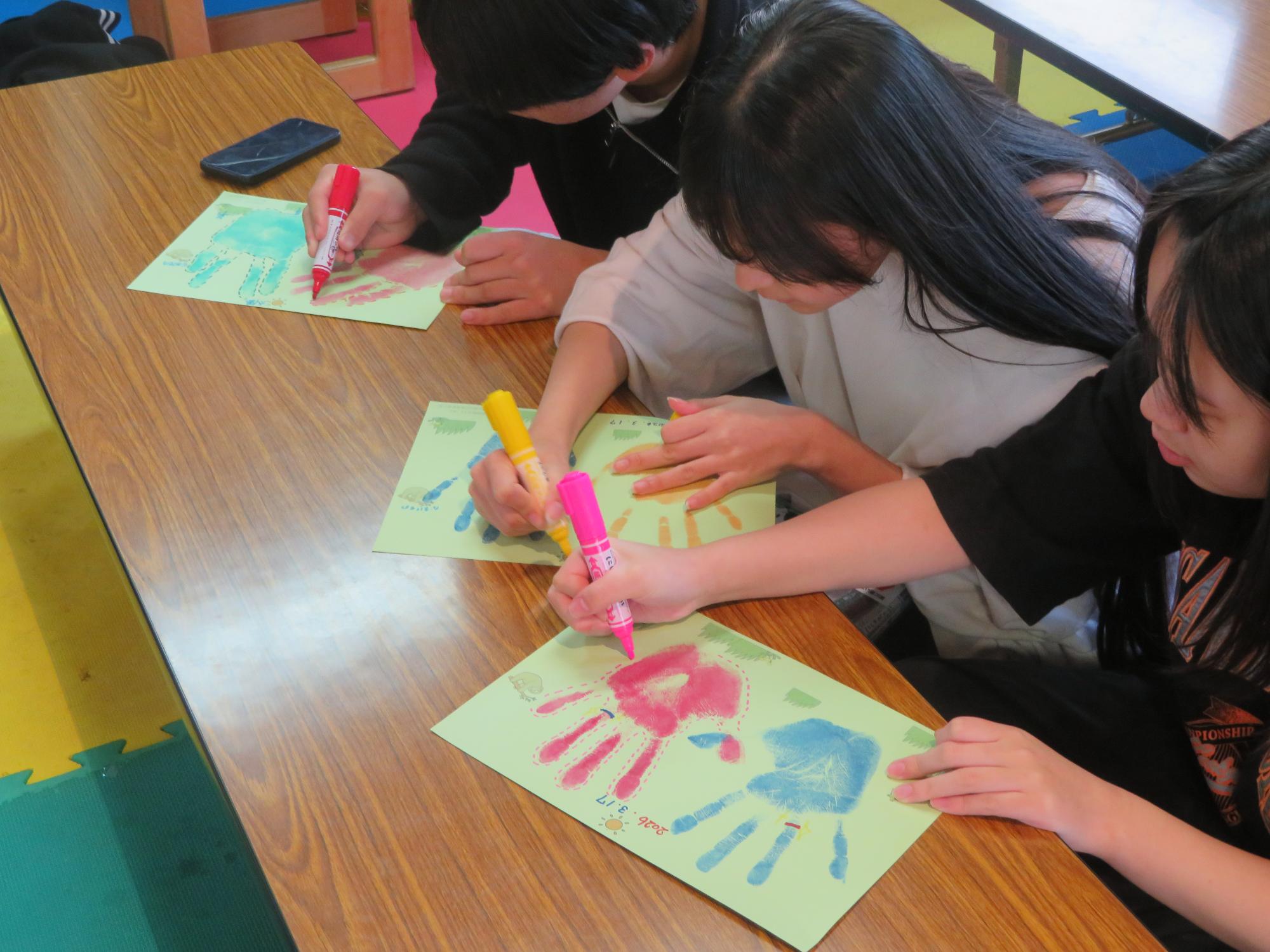 手形に絵を描いている写真