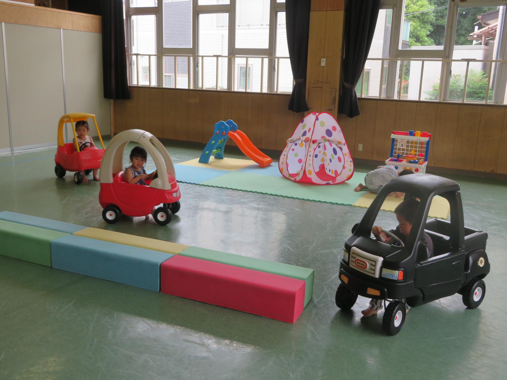 乗り物遊具に乗って遊ぶ幼児たちの写真