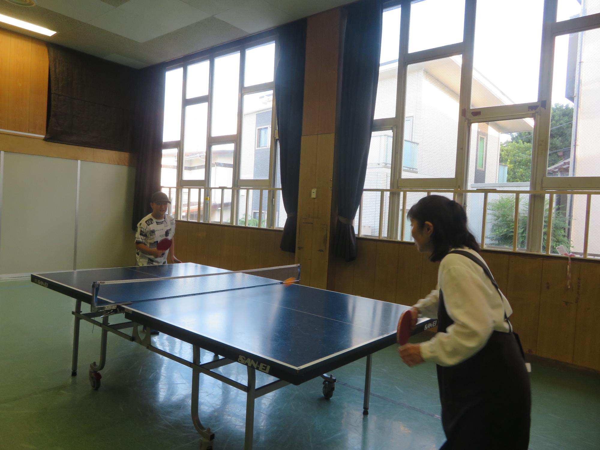 館長と卓球対決をする中学生の写真