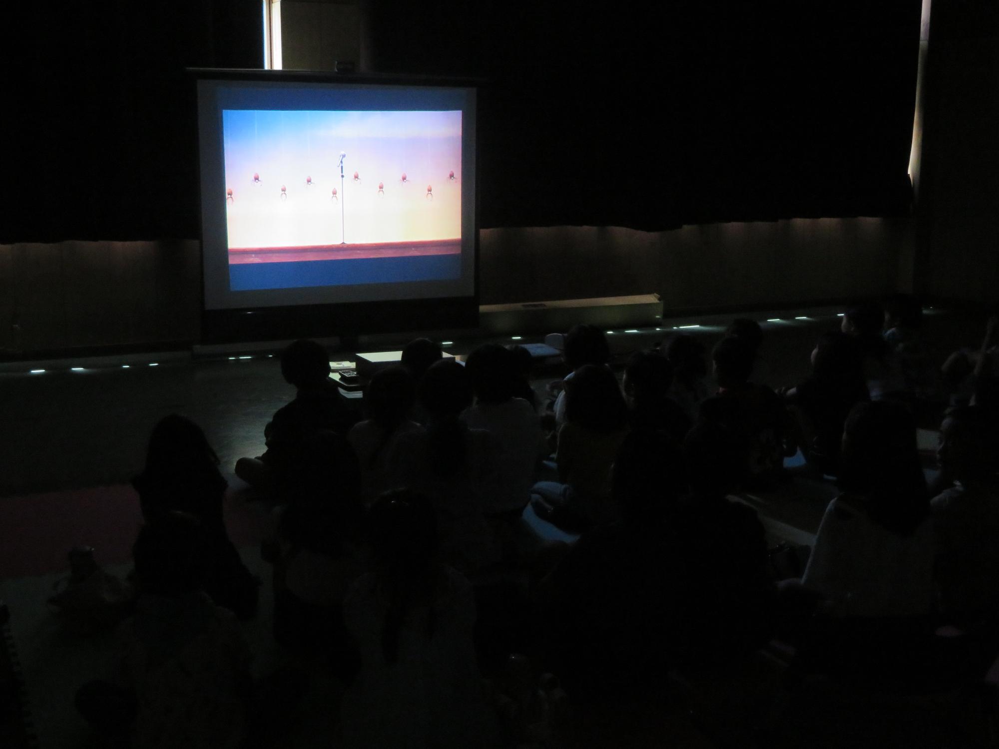 集会室で映画を楽しむ参加者たちの写真