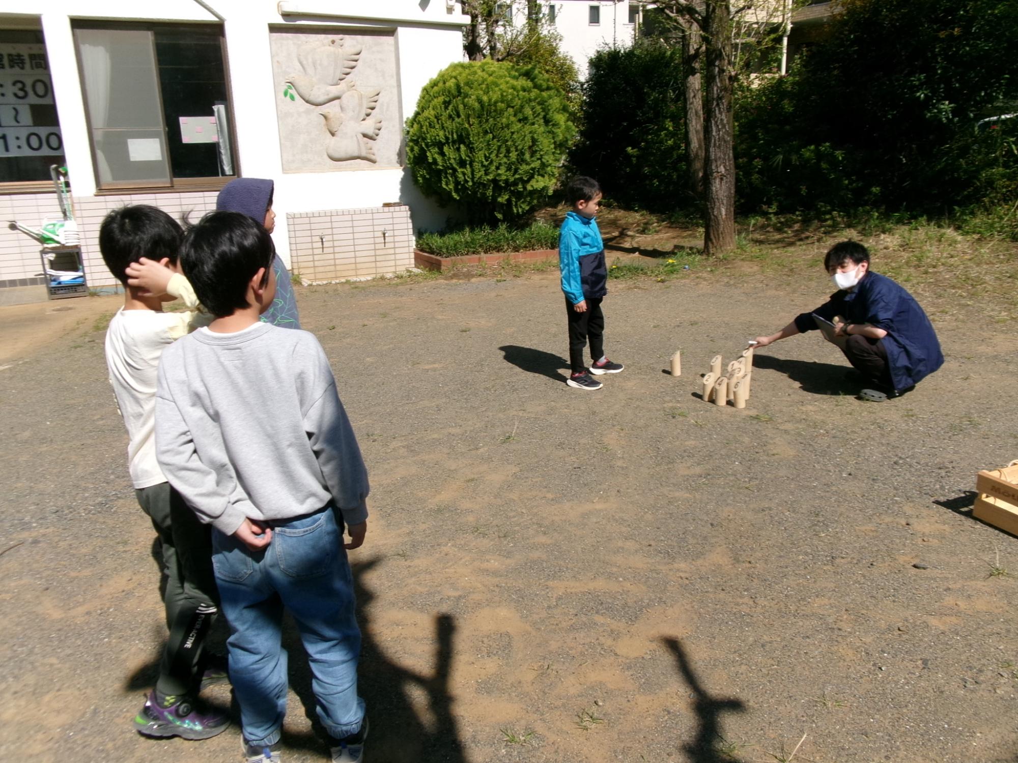 倒れたピンの点数を数えている様子と、点数に興味深々な児童の様子の写真