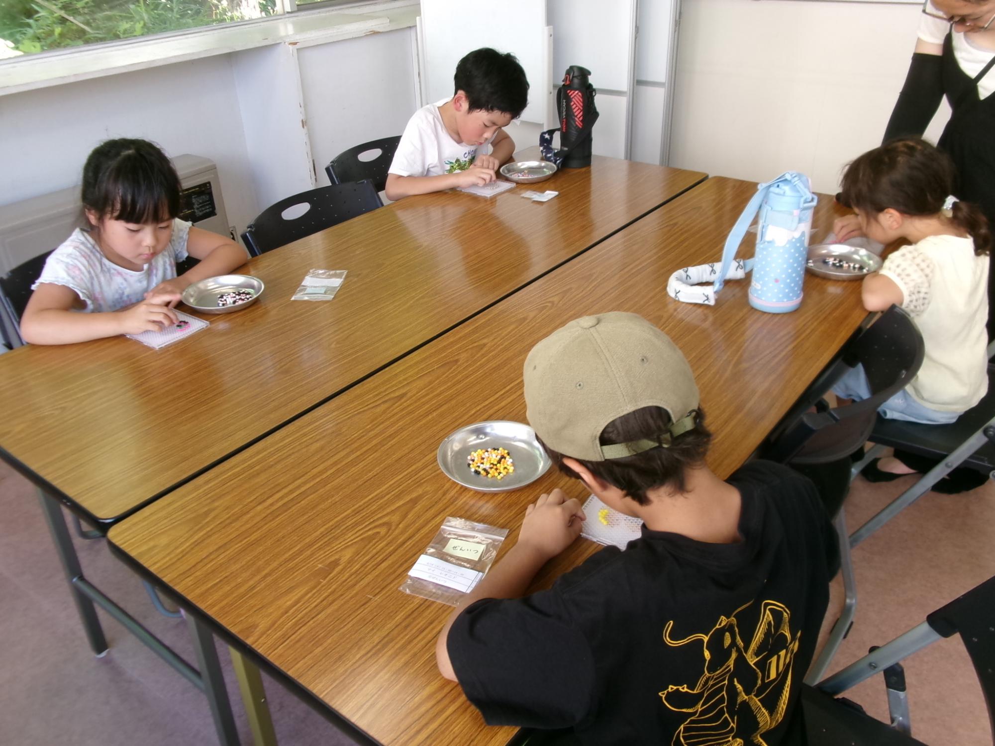 集中してビーズをトレイに置いている参加児童の様子の写真
