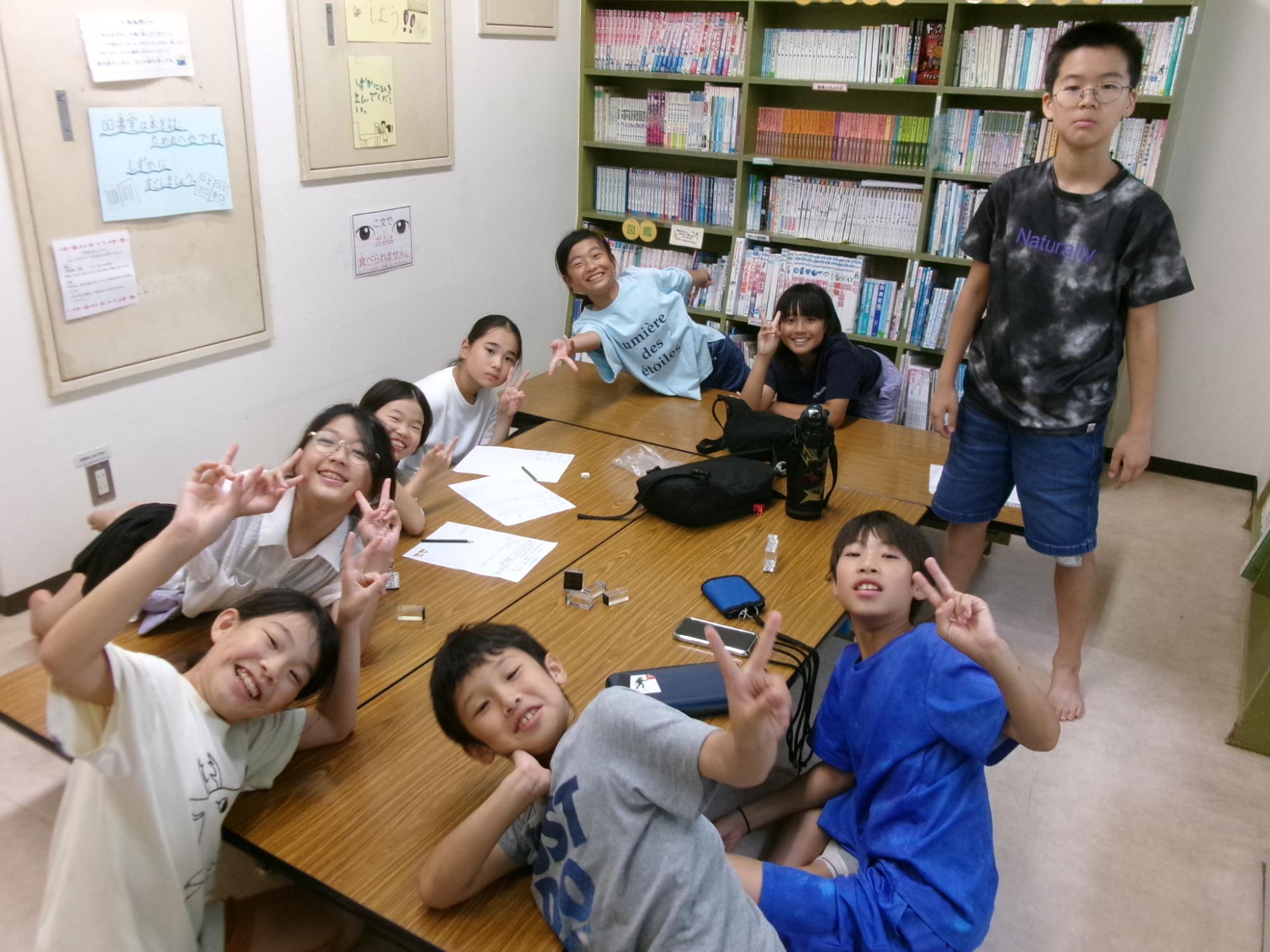 「こどもまんなか大作戦」という行事の実行委員の小学生たちが楽しげにピースをしている様子の写真