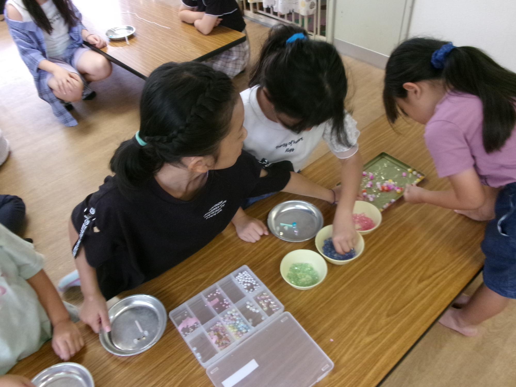 参加児童がビーズを選んでいる様子の写真