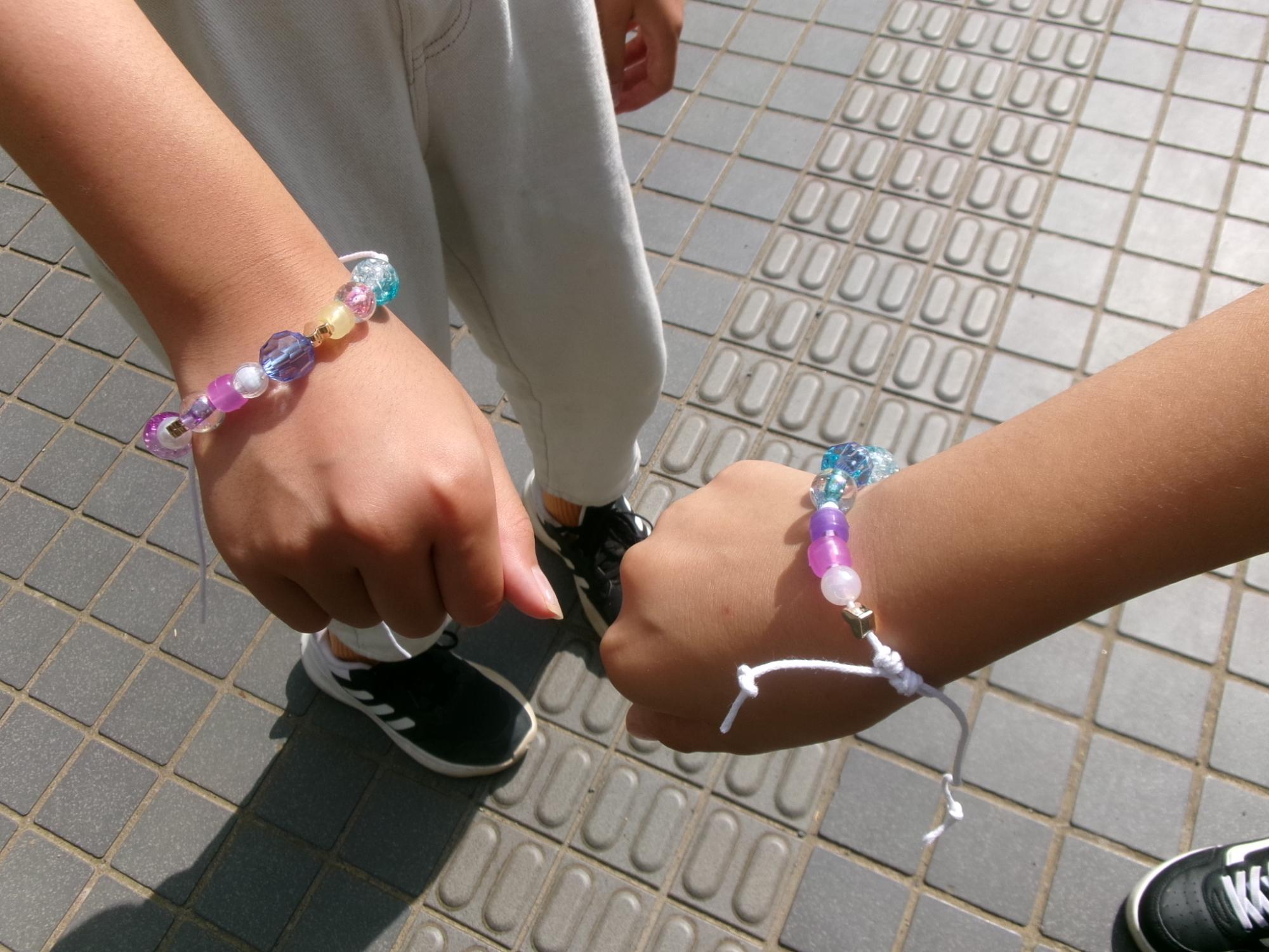 ピンクや紫など、色とりどりのビーズのブレスレットの写真