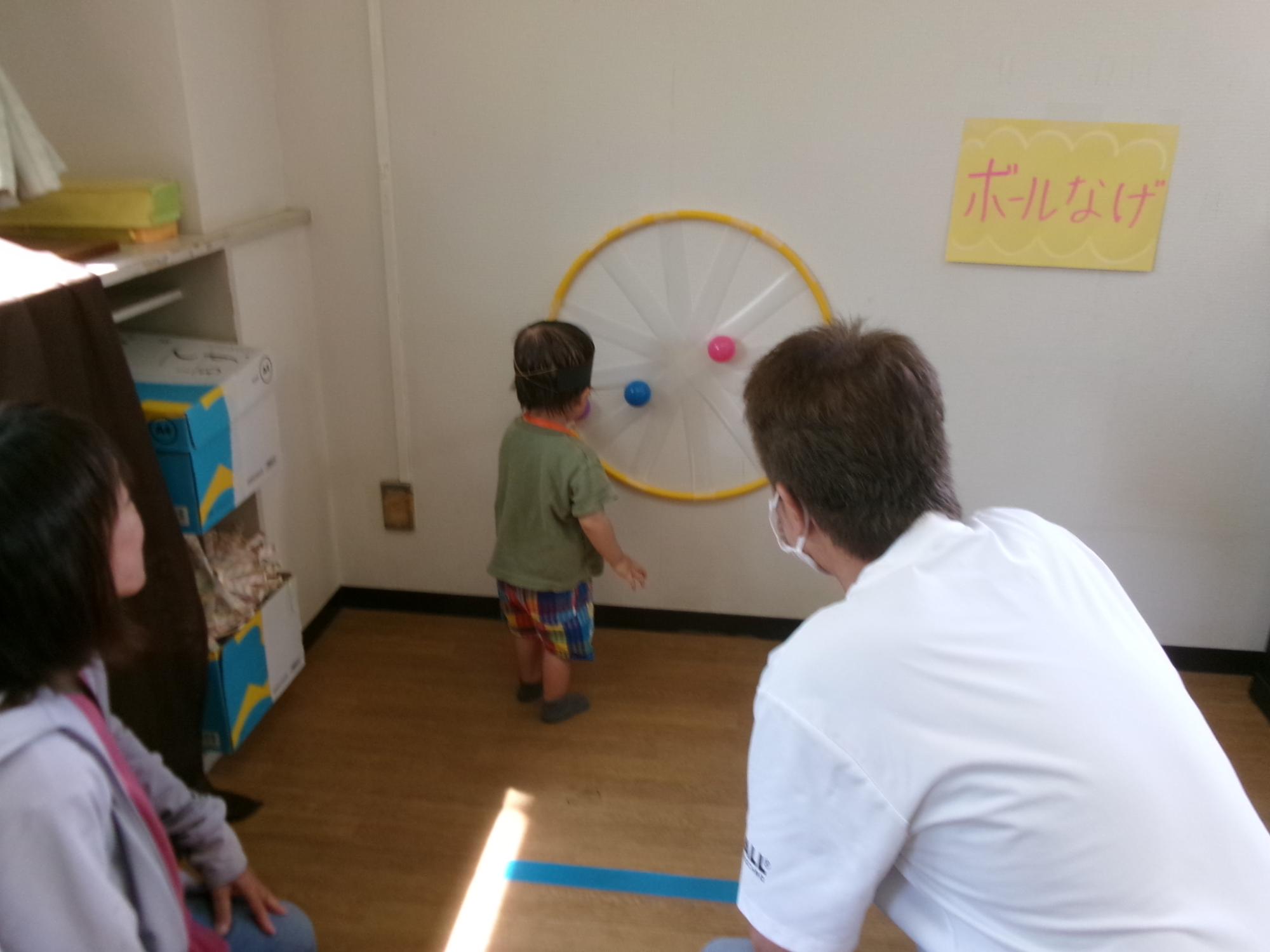 参加した幼児がボール投げブースでテープにボールをくっつけている様子の写真