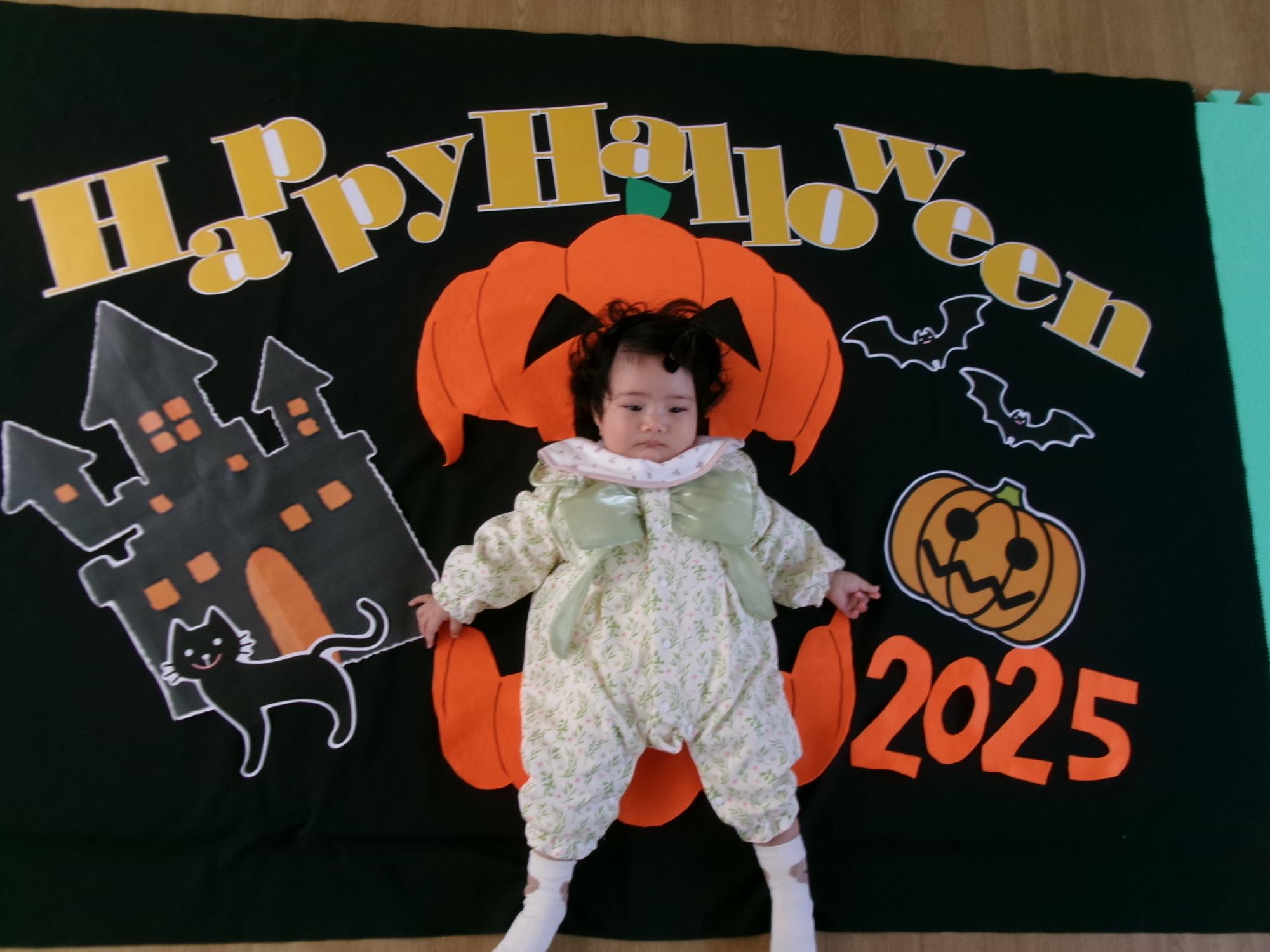 背景の上で寝っ転がって撮った赤ちゃんの様子の写真