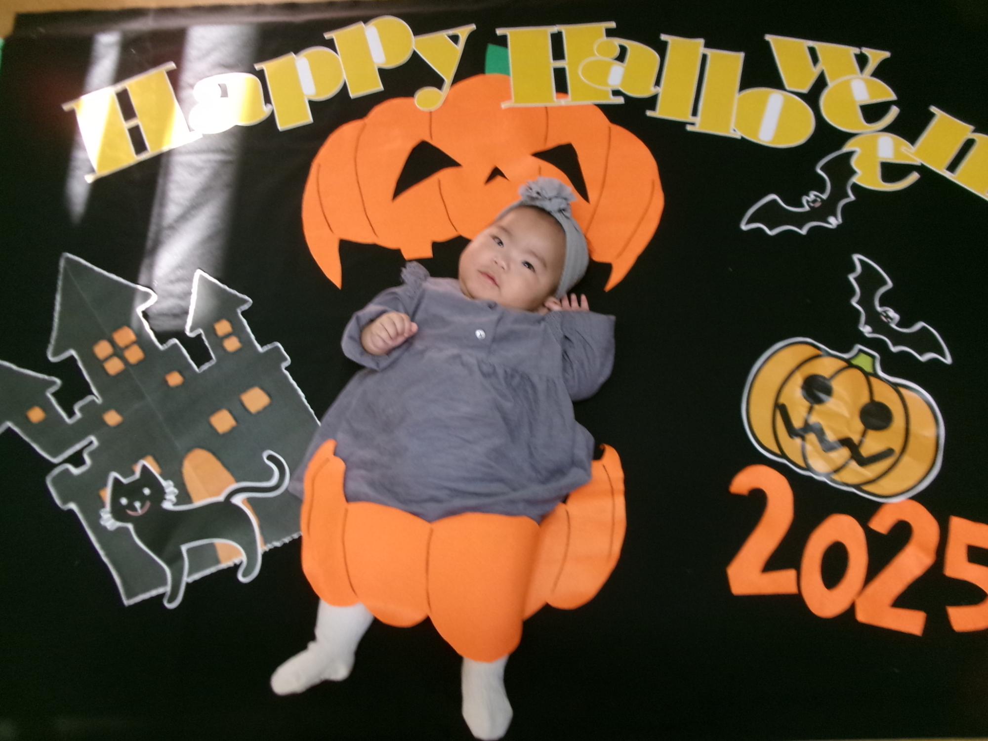 背景の上で寝っ転がって撮った赤ちゃんの写真