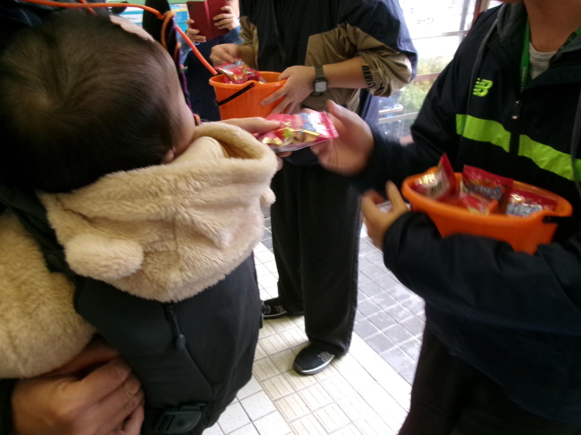 赤ちゃんがお菓子を受け取っている様子の写真