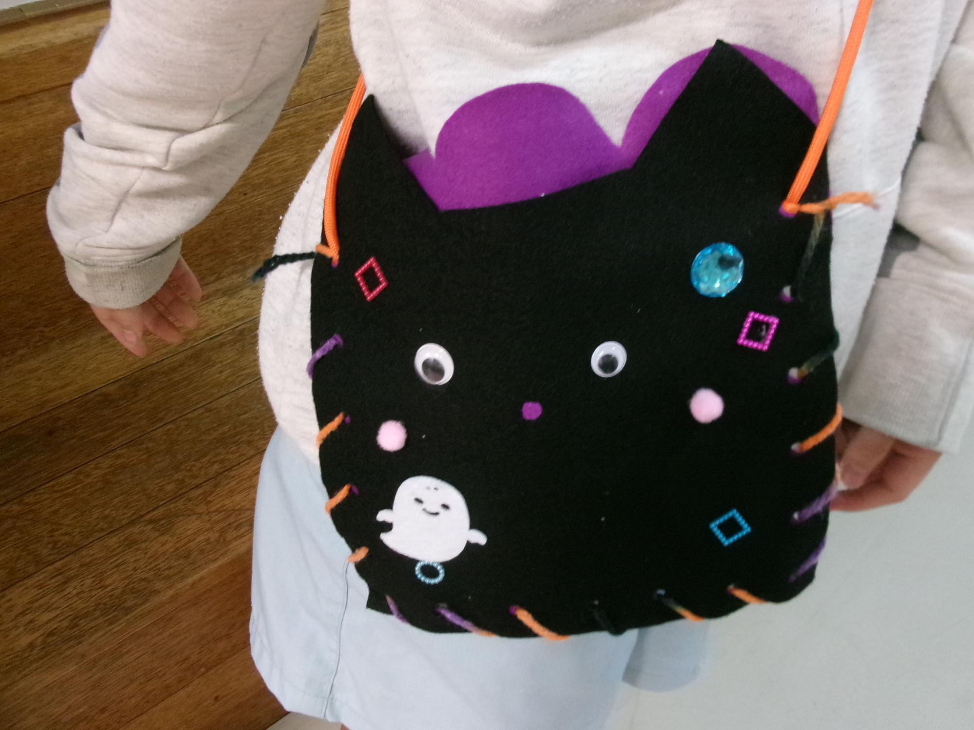 おばけやきらきらの装飾がついた猫の形のバッグの写真