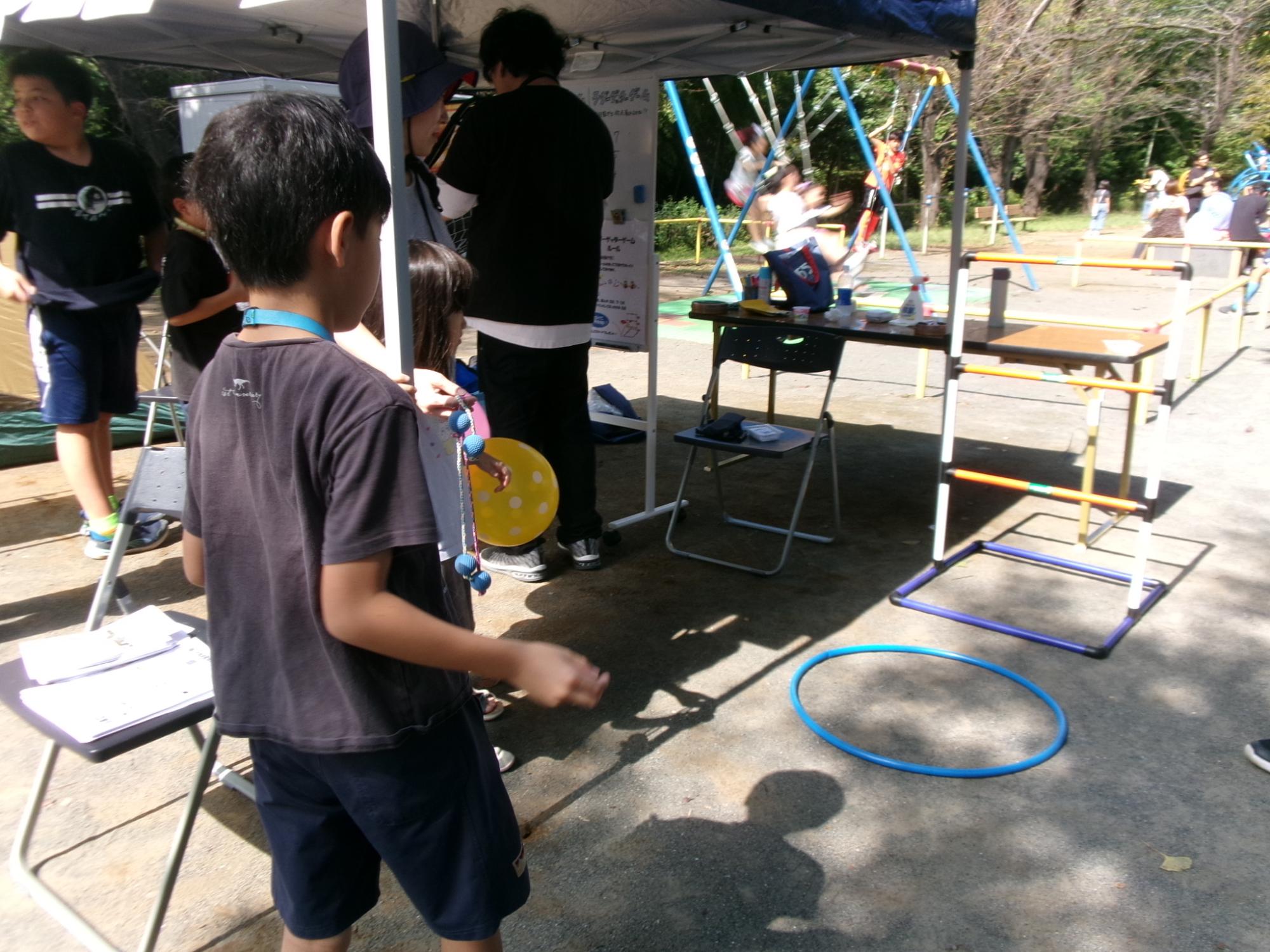 ひもでつながっているボールを投げて棒にひっかける「ラダーゲッター」ブースの様子の写真