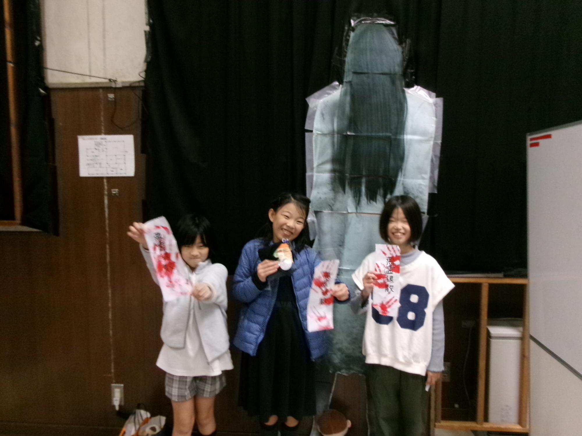 作成したおばけのパネルの前で子ども実行委員が集合写真を撮っている様子の写真