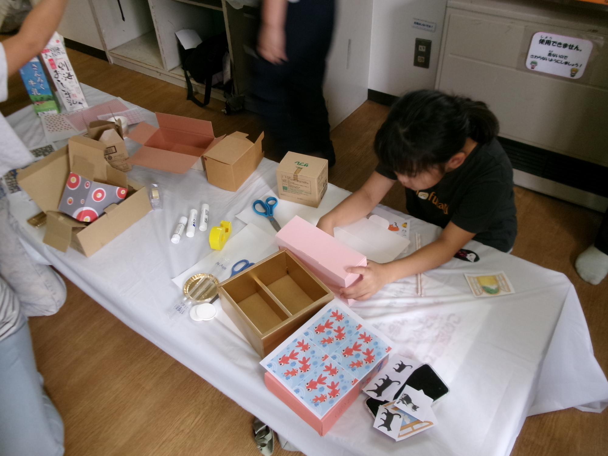 箱を使って自由に工作をしている子どもの様子の写真