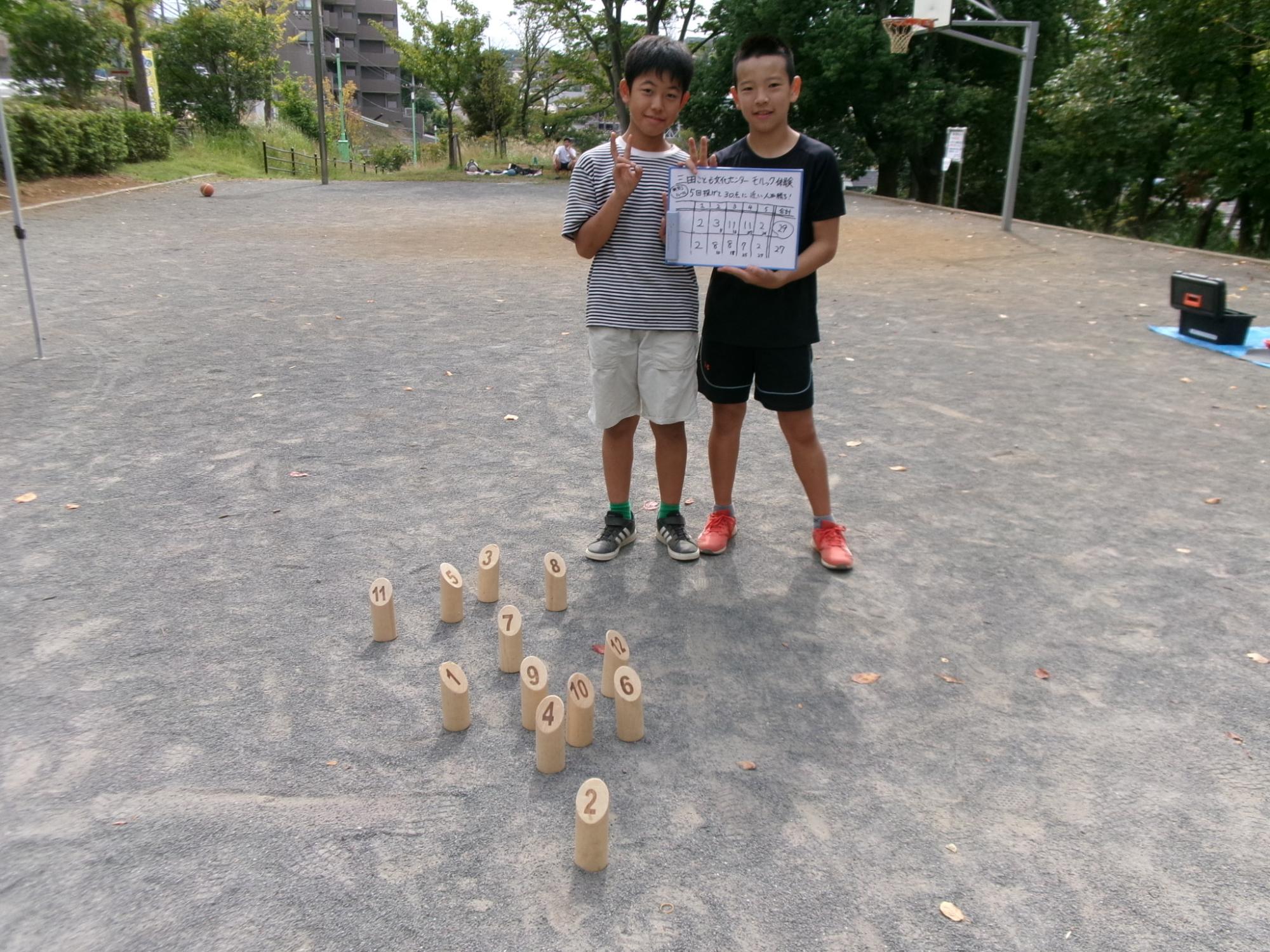 対戦後に得点表を持って記念撮影をしている子どもの様子の写真