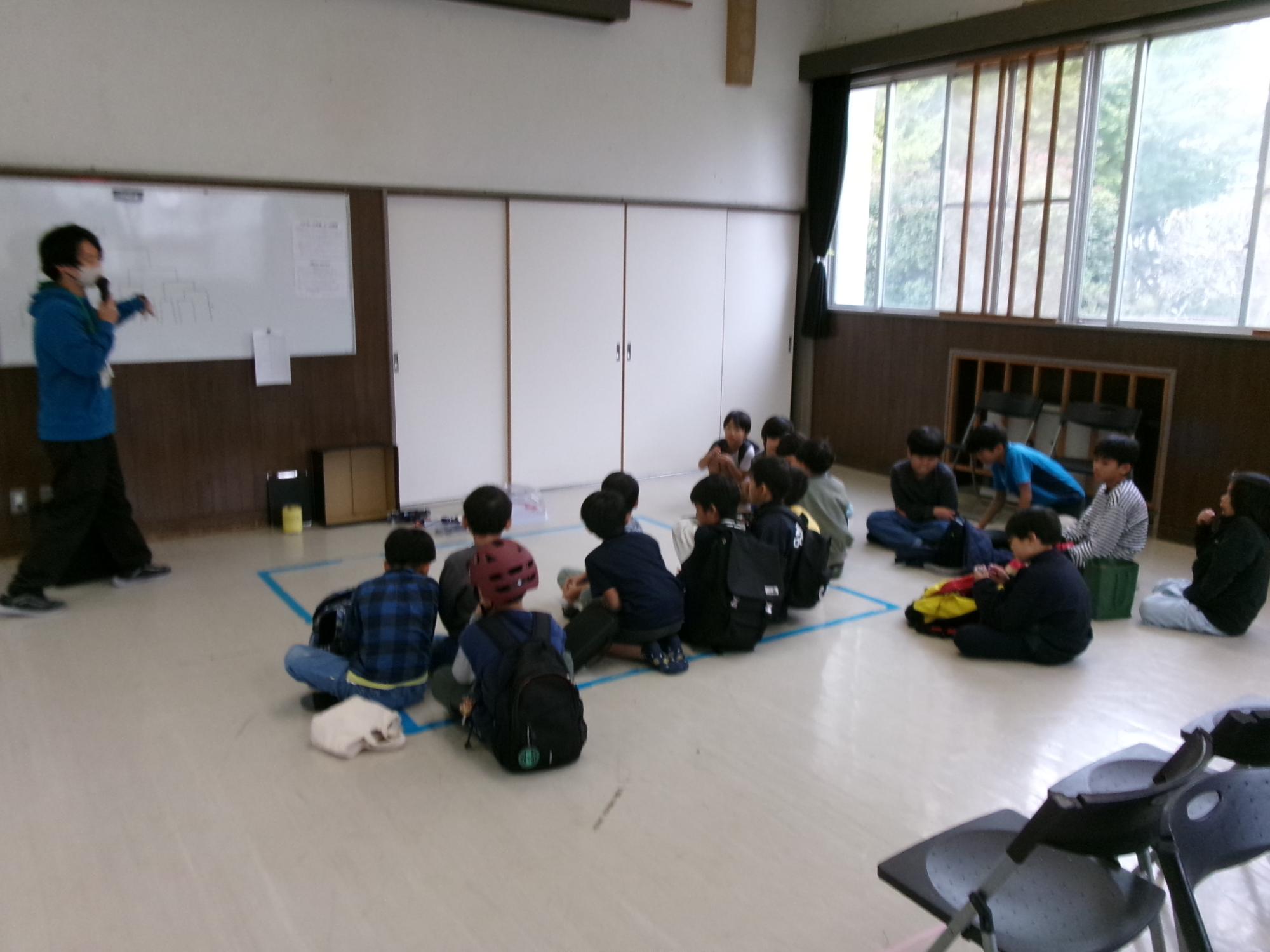 ベイブレード大会で参加者がルール説明を聞いている様子の写真