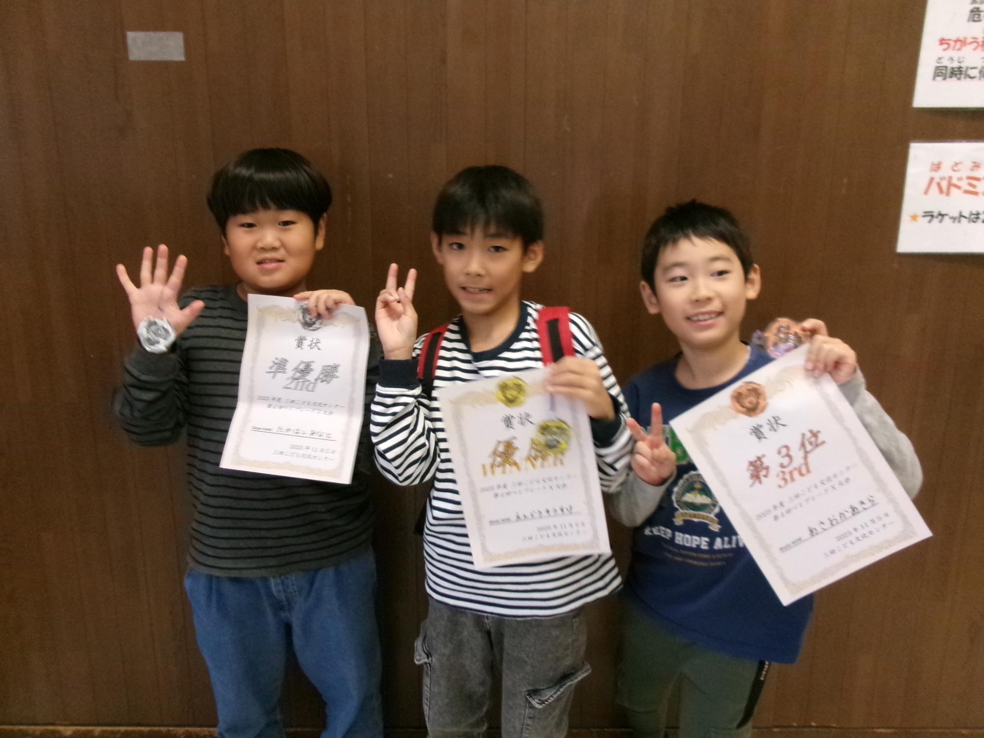 小学生がベイブレード大会で入賞し賞状を持っている写真