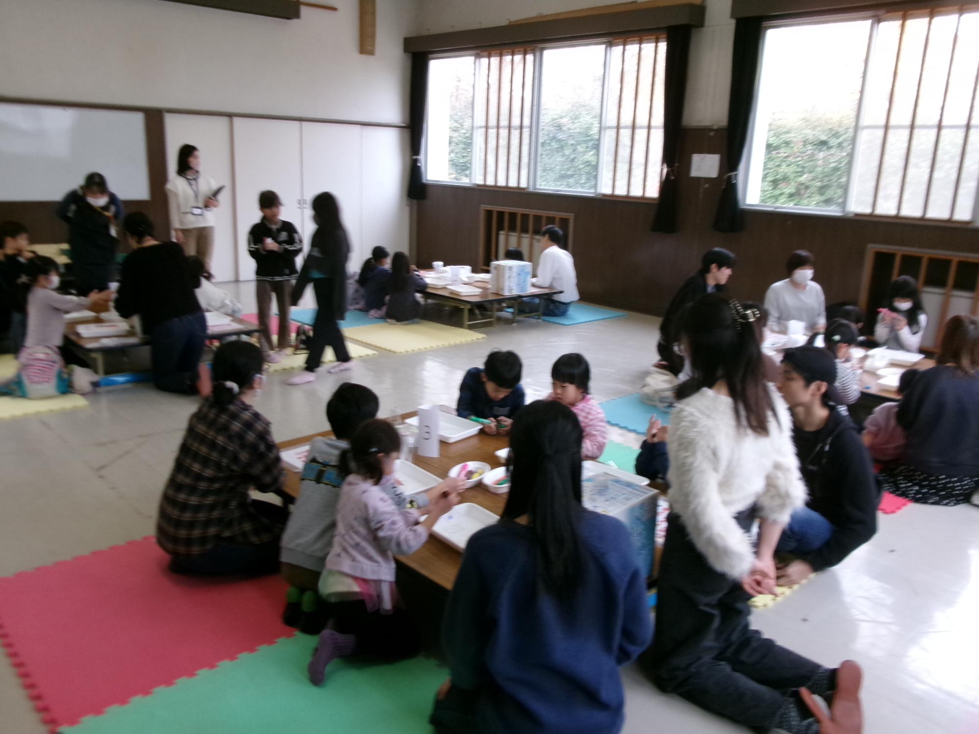 グループにわかれて小学生や乳幼児親子が実験をしている様子の写真
