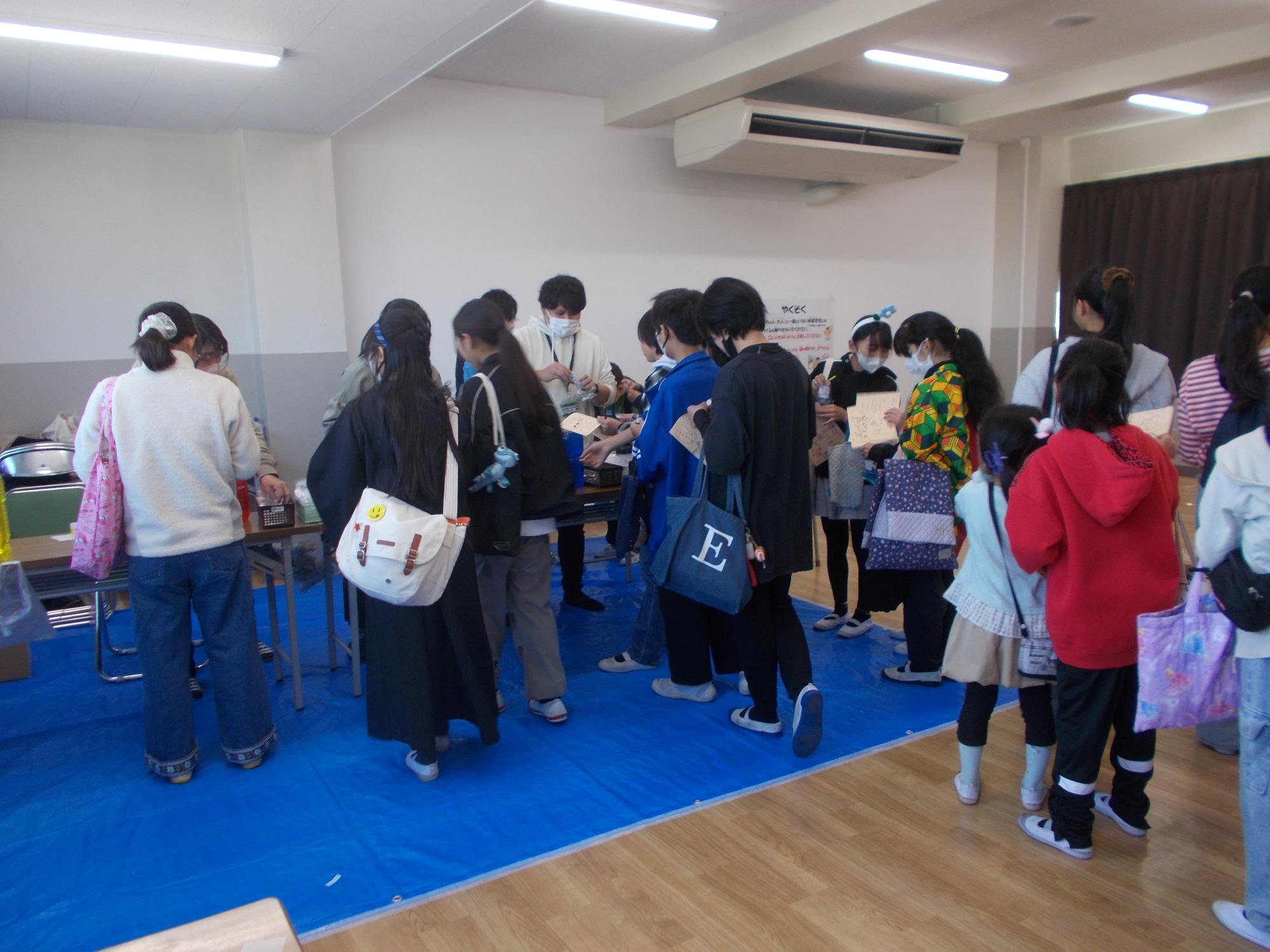 スライム作りの会場で参加者が並んでいる様子の写真